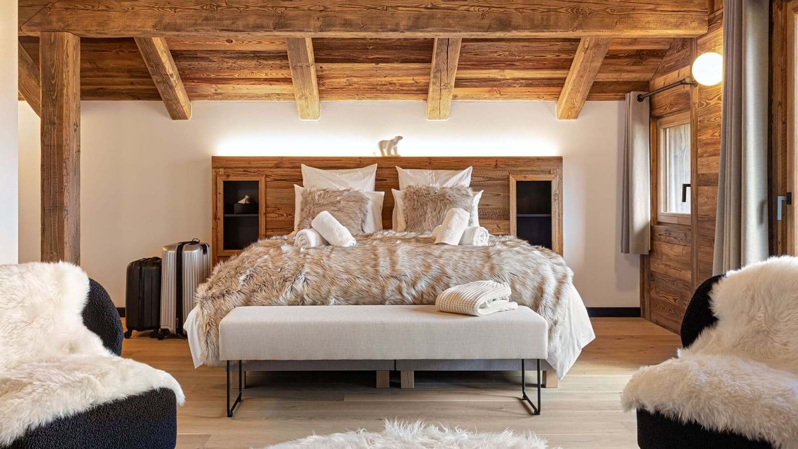 King bedroom with exposed timber beams and built-in headboard shelving