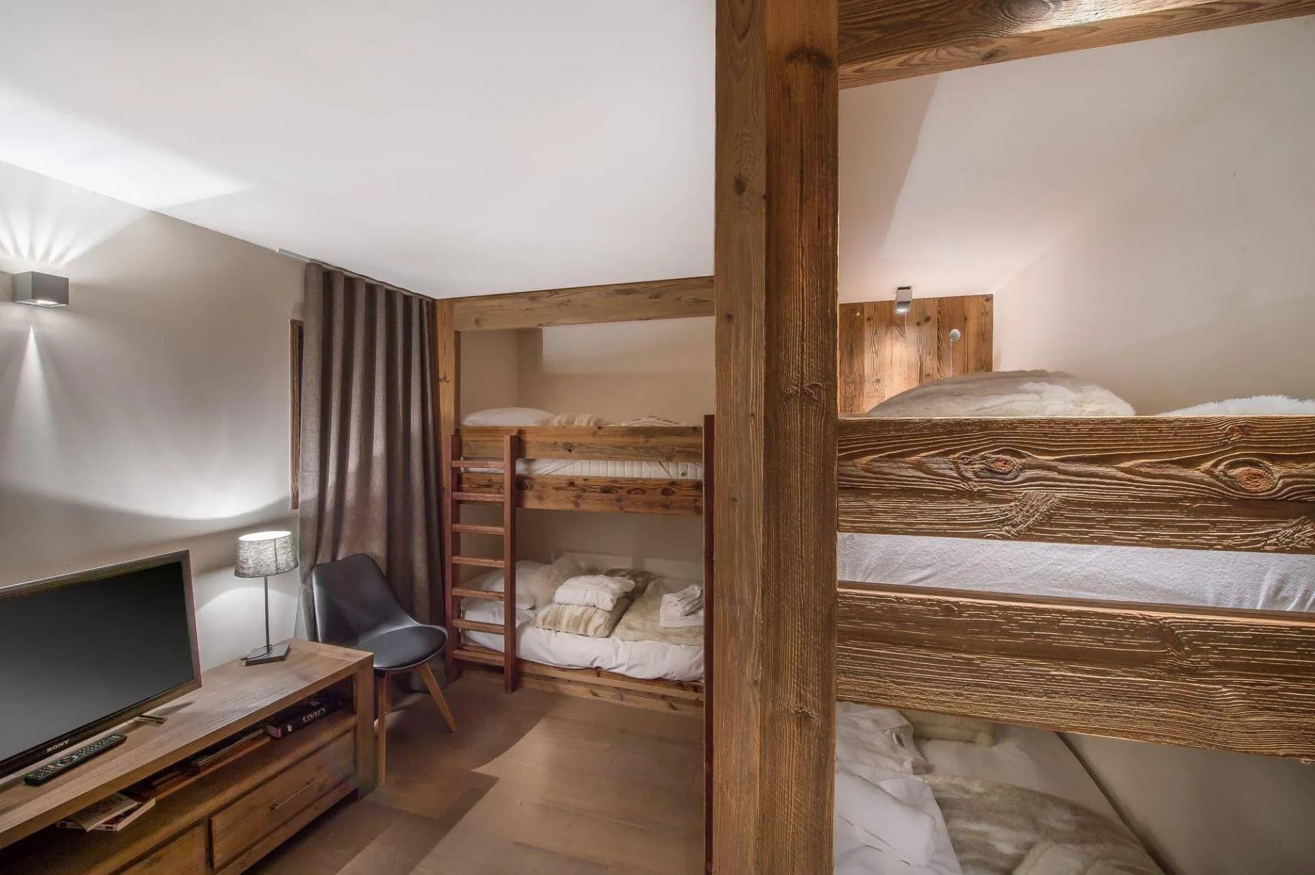 Children’s room with two bunk-bed frames and television
