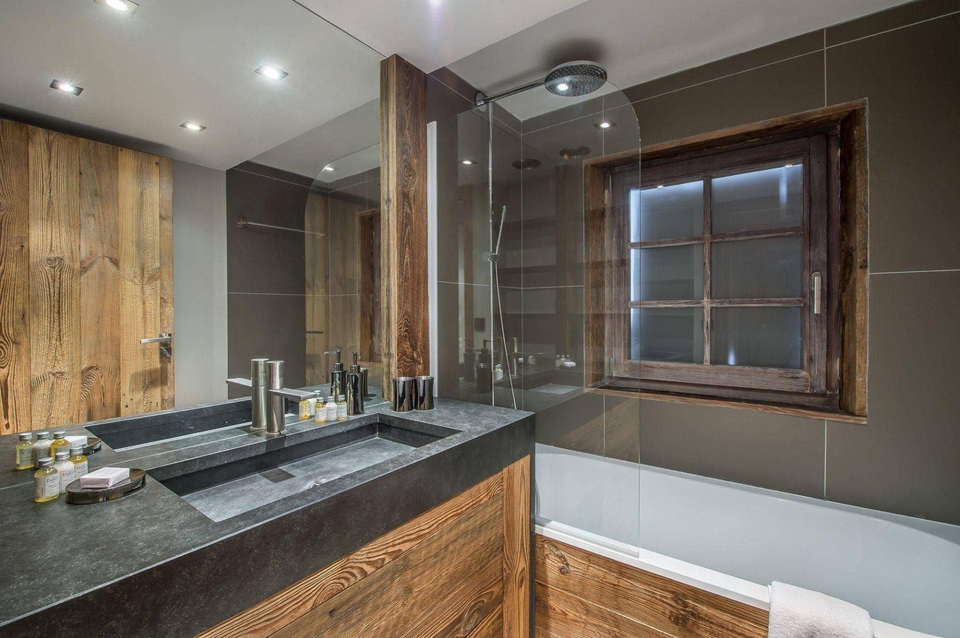 Bathroom with trough sink and rainfall shower over deep soaking tub