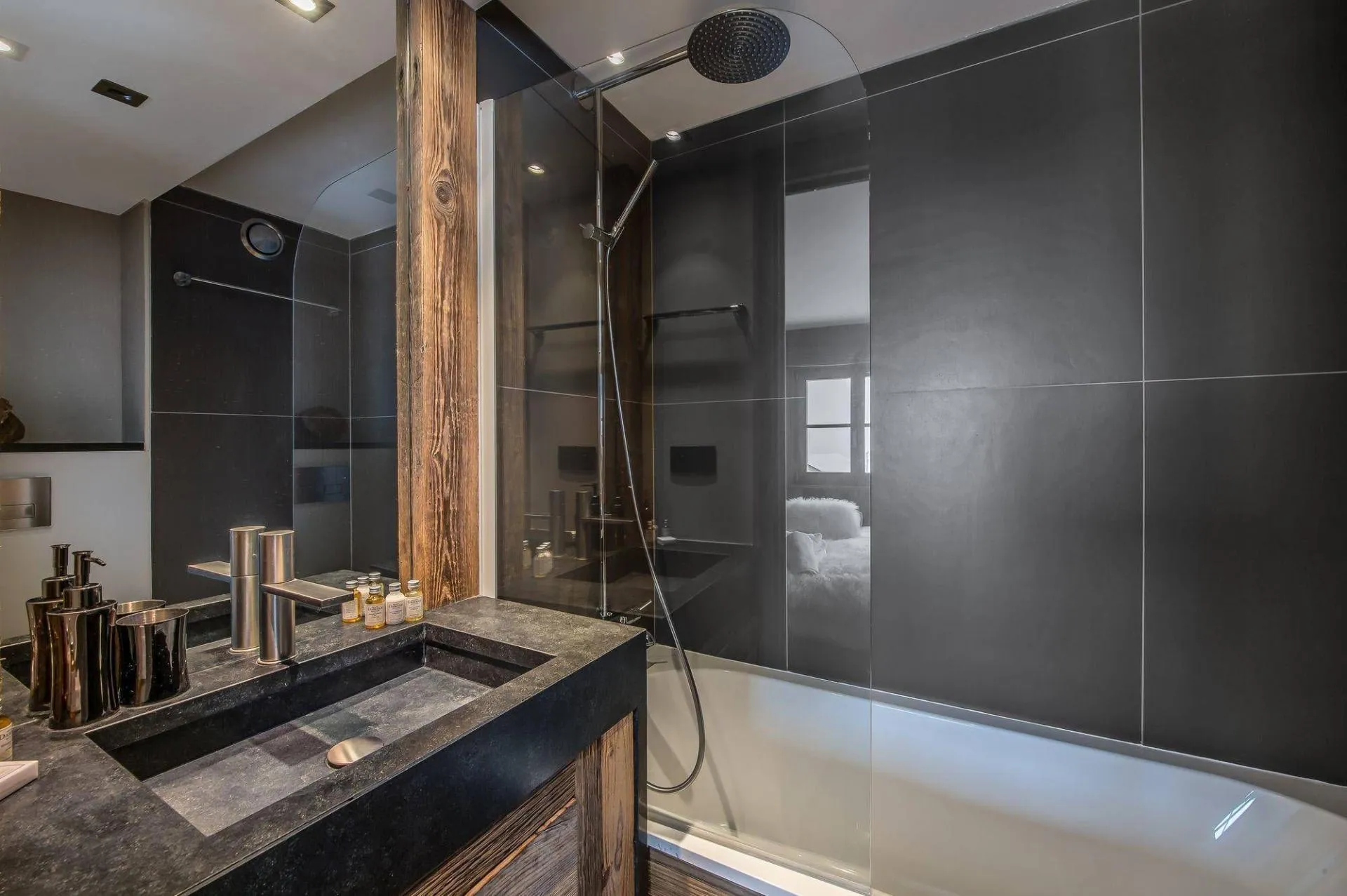 Bathroom with bathtub and dark tiled walls