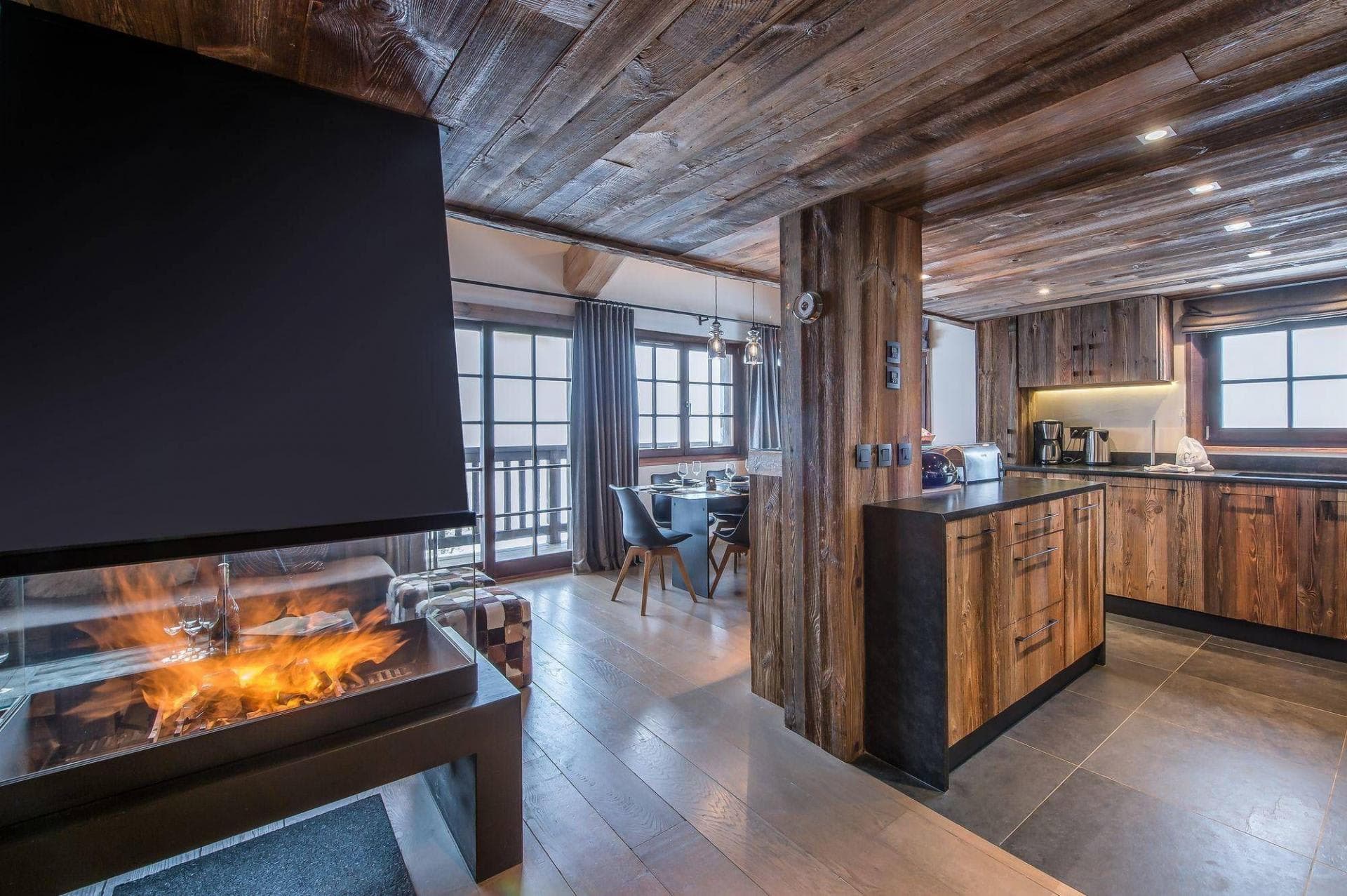 Open-plan living area featuring three-sided fireplace and reclaimed wood finishes