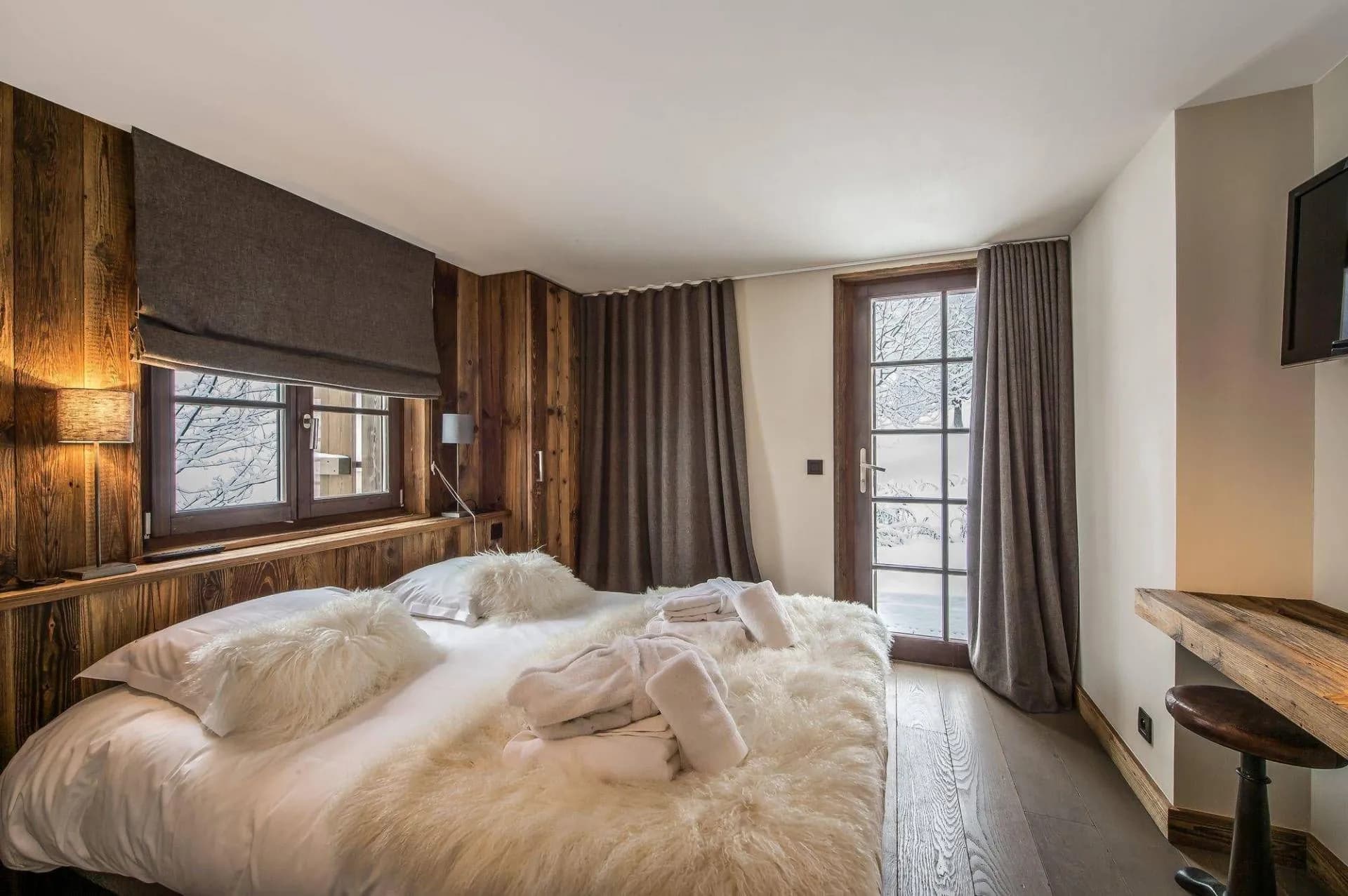 Double bedroom with timber walls and glazed door