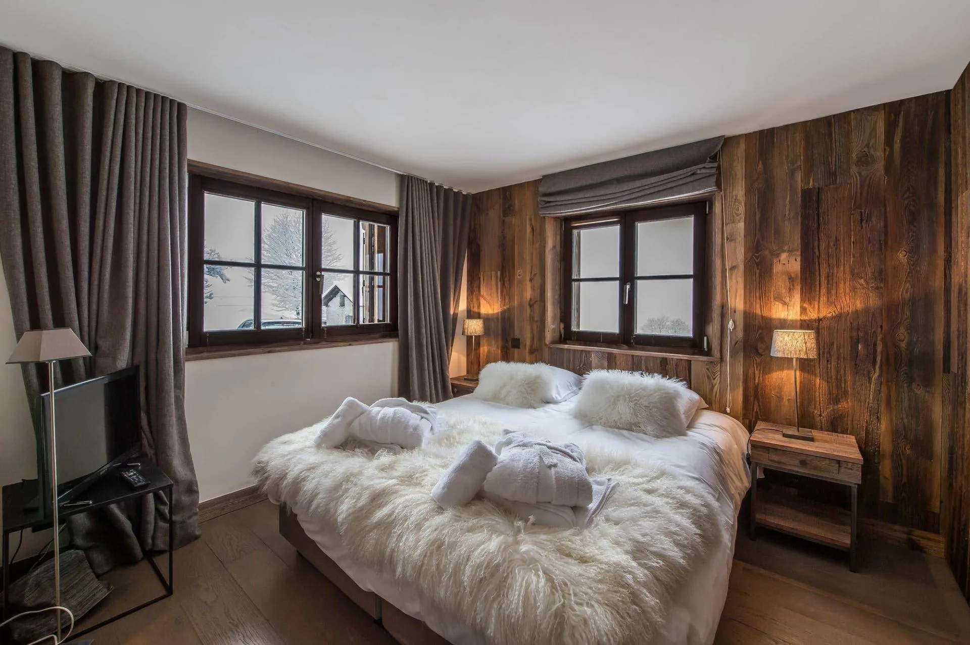 Double bedroom with timber wall and corner windows