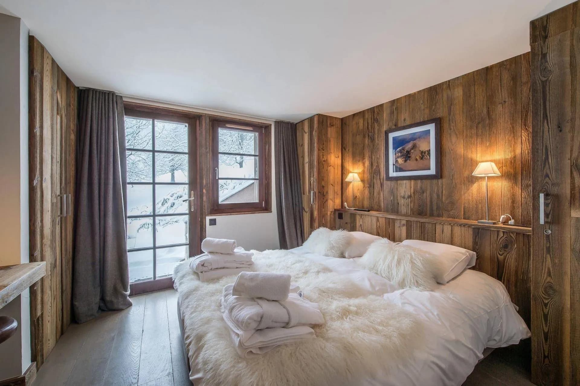 Double bedroom with timber wall and large glazed door