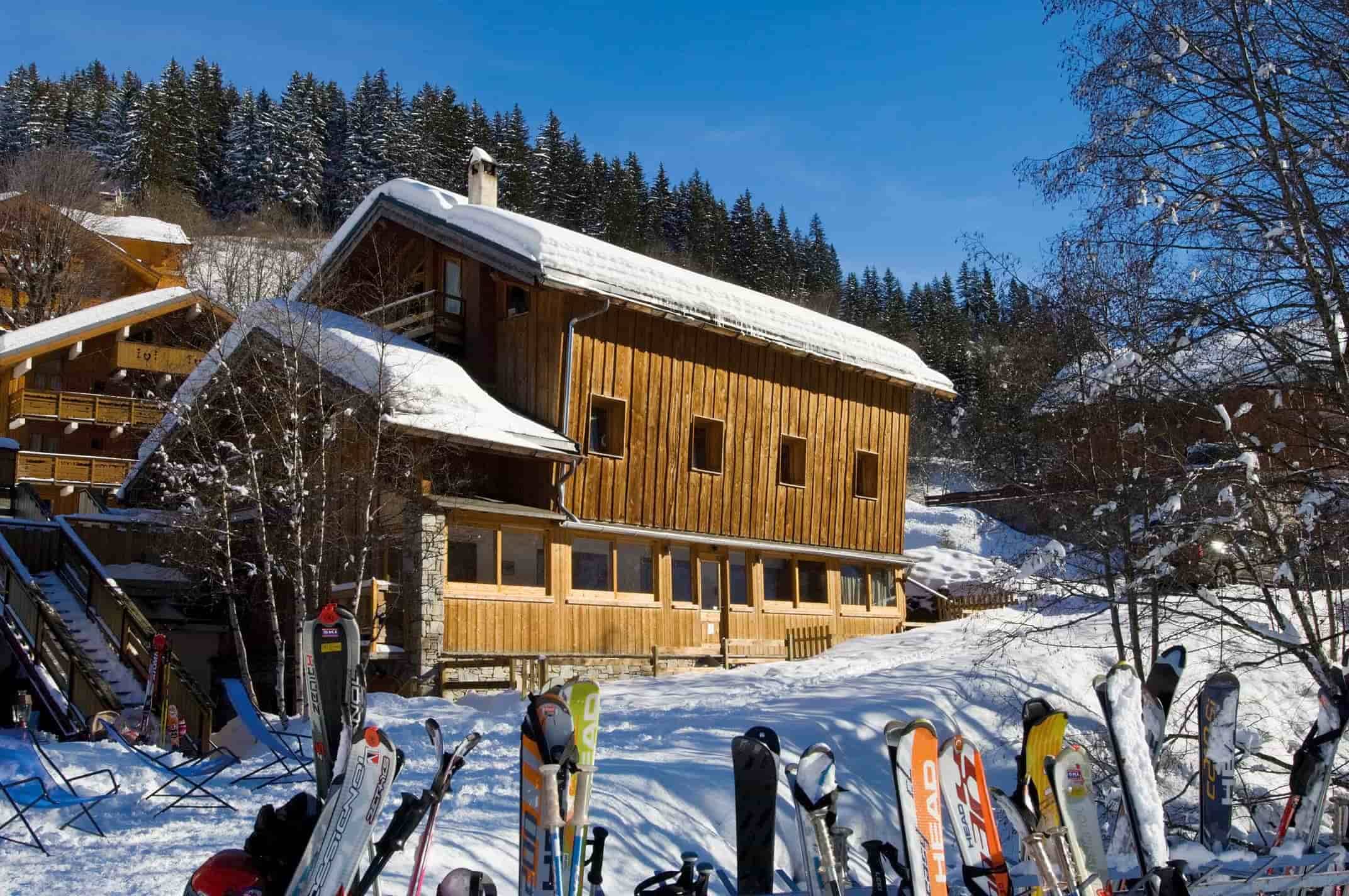 Ski-in/ski-out chalet exterior with designated ski rack and forest backdrop