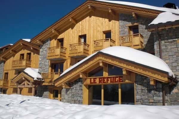 Ski-in ski-out chalet exterior with private balconies and stone masonry