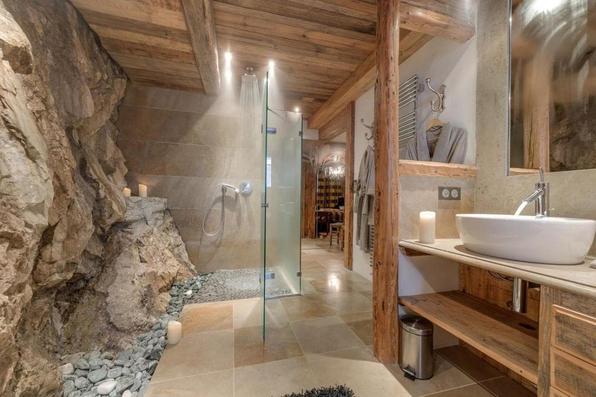 Bathroom featuring exposed natural rock wall and walk-in rain shower