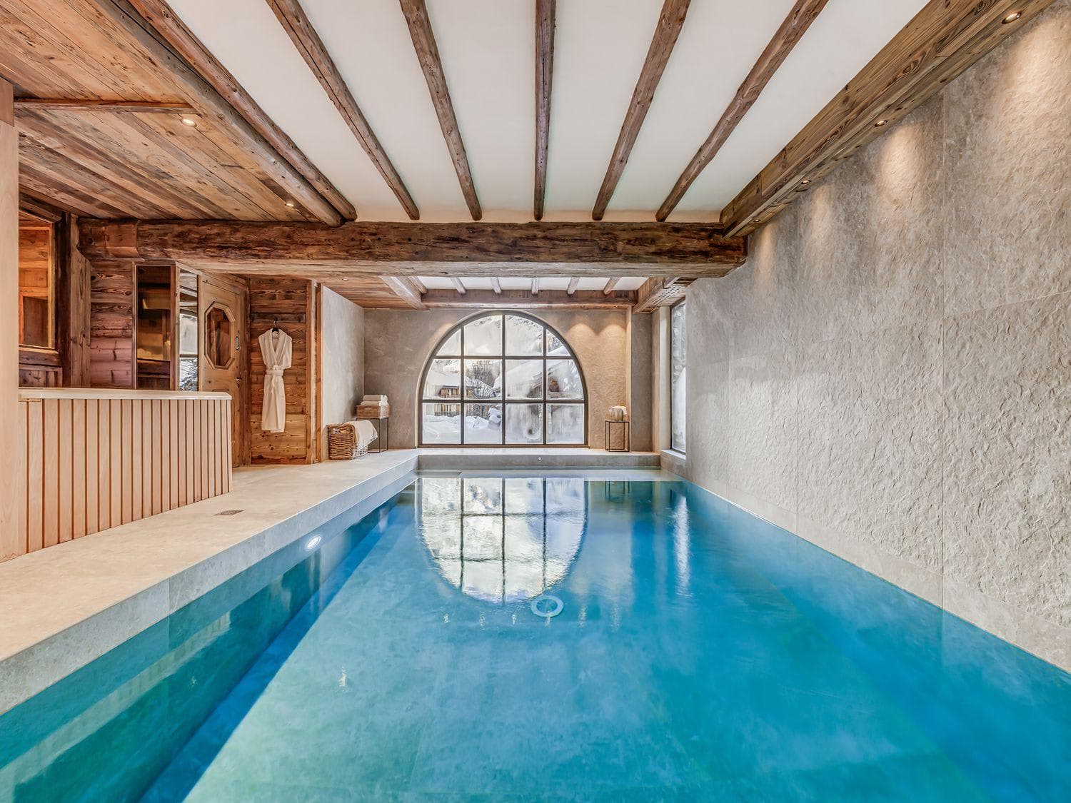 Indoor pool with adjacent sauna and reclaimed timber ceiling