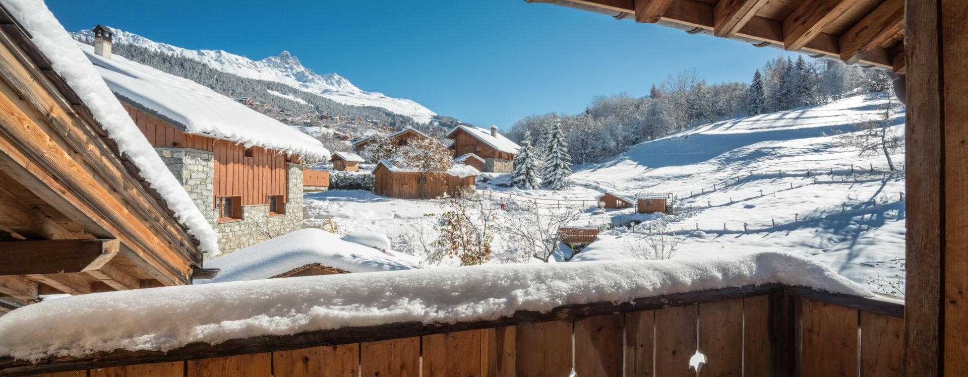 Private balcony view of snow-covered village and surrounding mountains