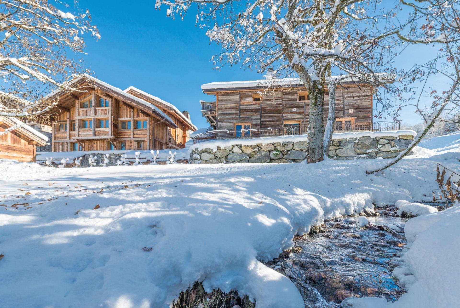 Timber chalets with stone retaining wall and creek access