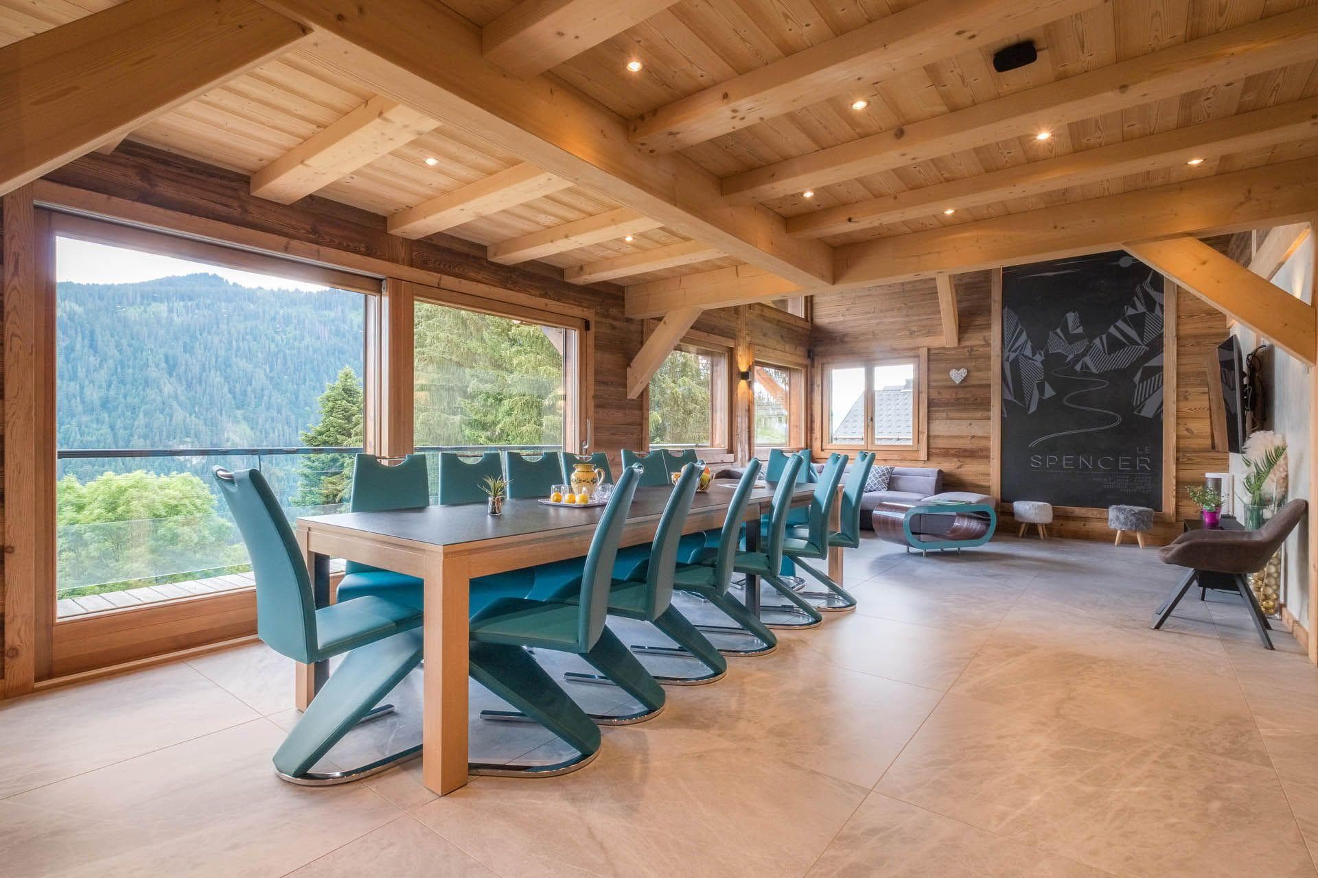 Dining area seats 12 with floor-to-ceiling forest and mountain views