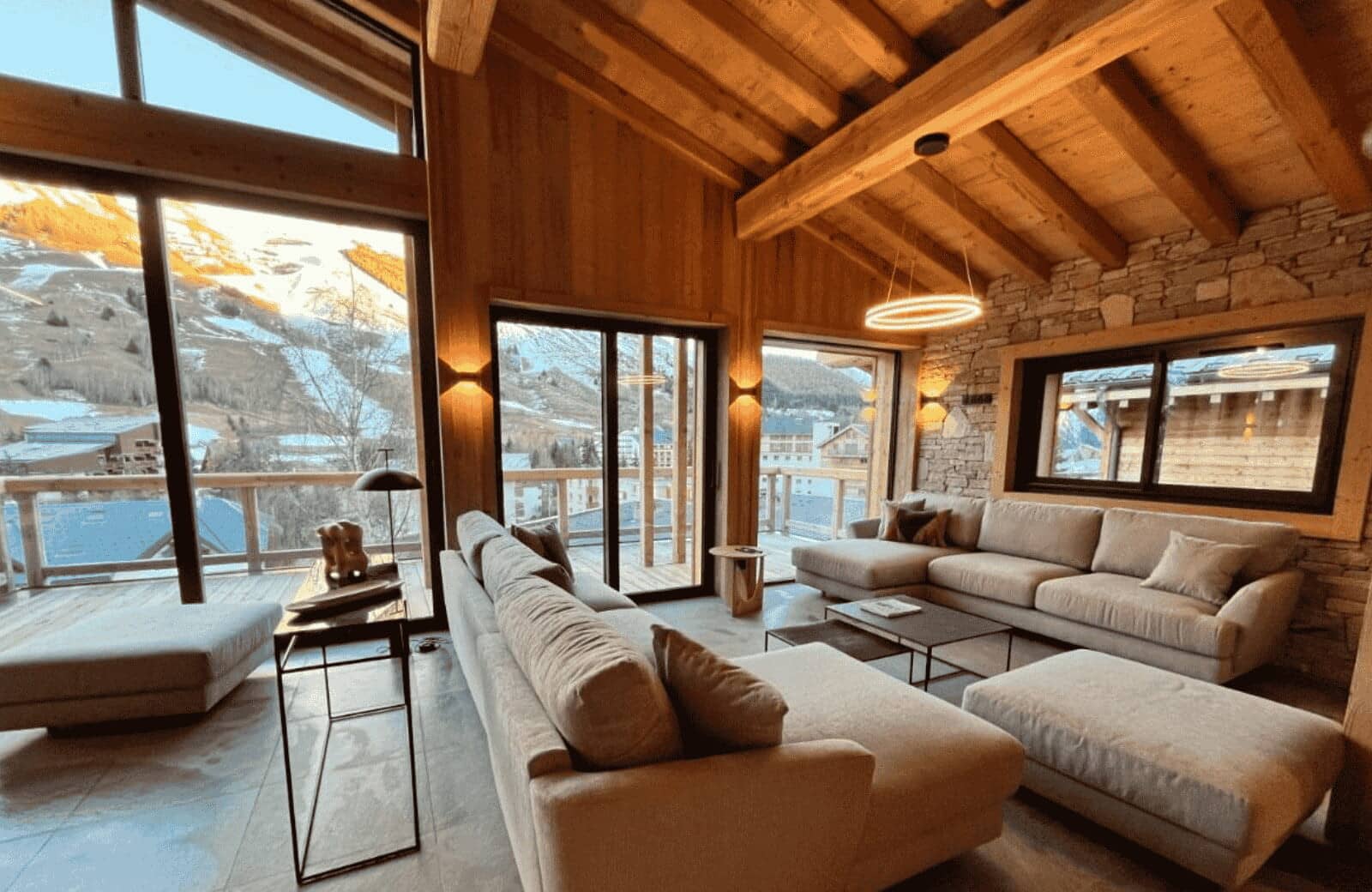 Living room with two large sectionals and floor-to-ceiling alpine views