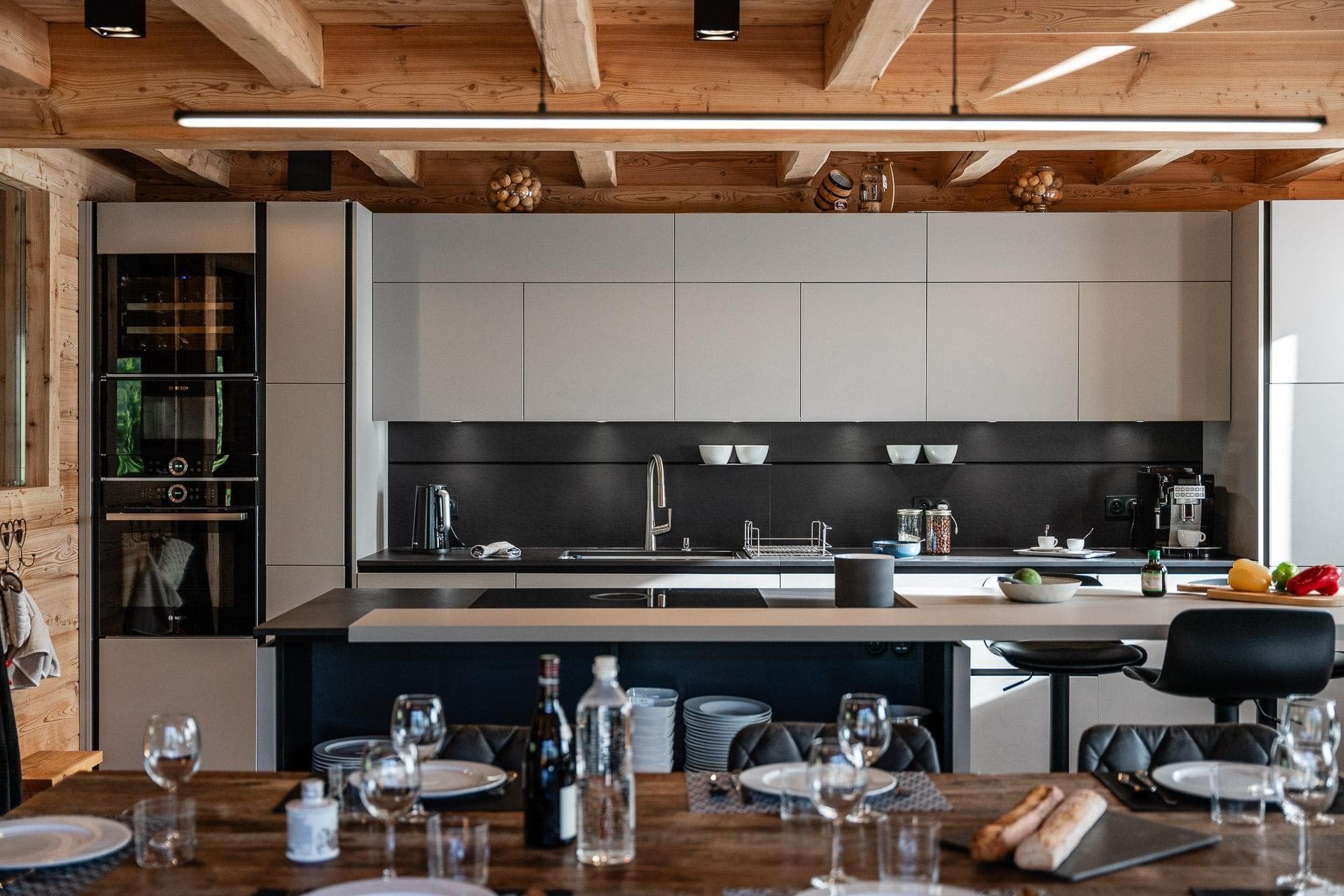 Kitchen with induction cooktop, wine fridge, and exposed wood beams