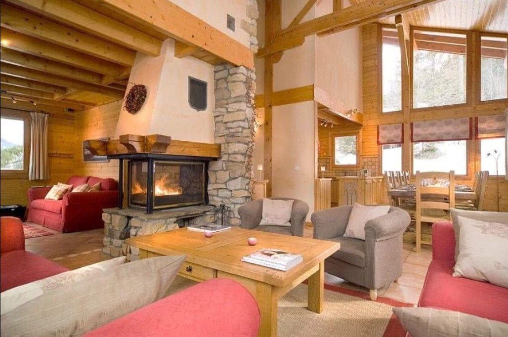 Open-plan living area with wood-burning fireplace and double-height ceilings