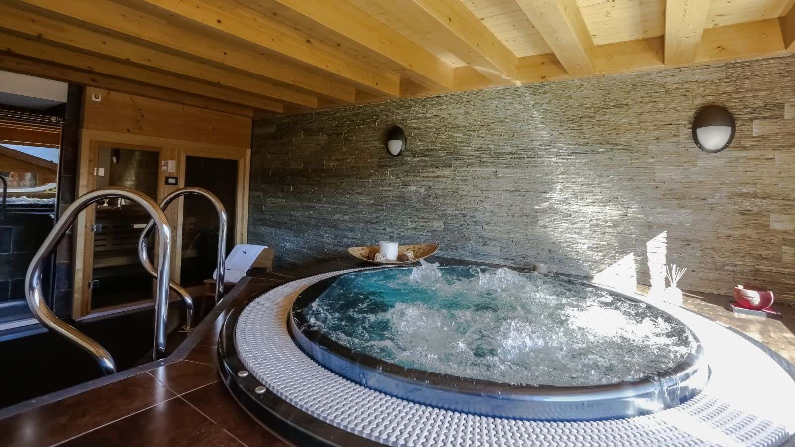 Indoor spa area with sunken circular hot tub and adjacent sauna