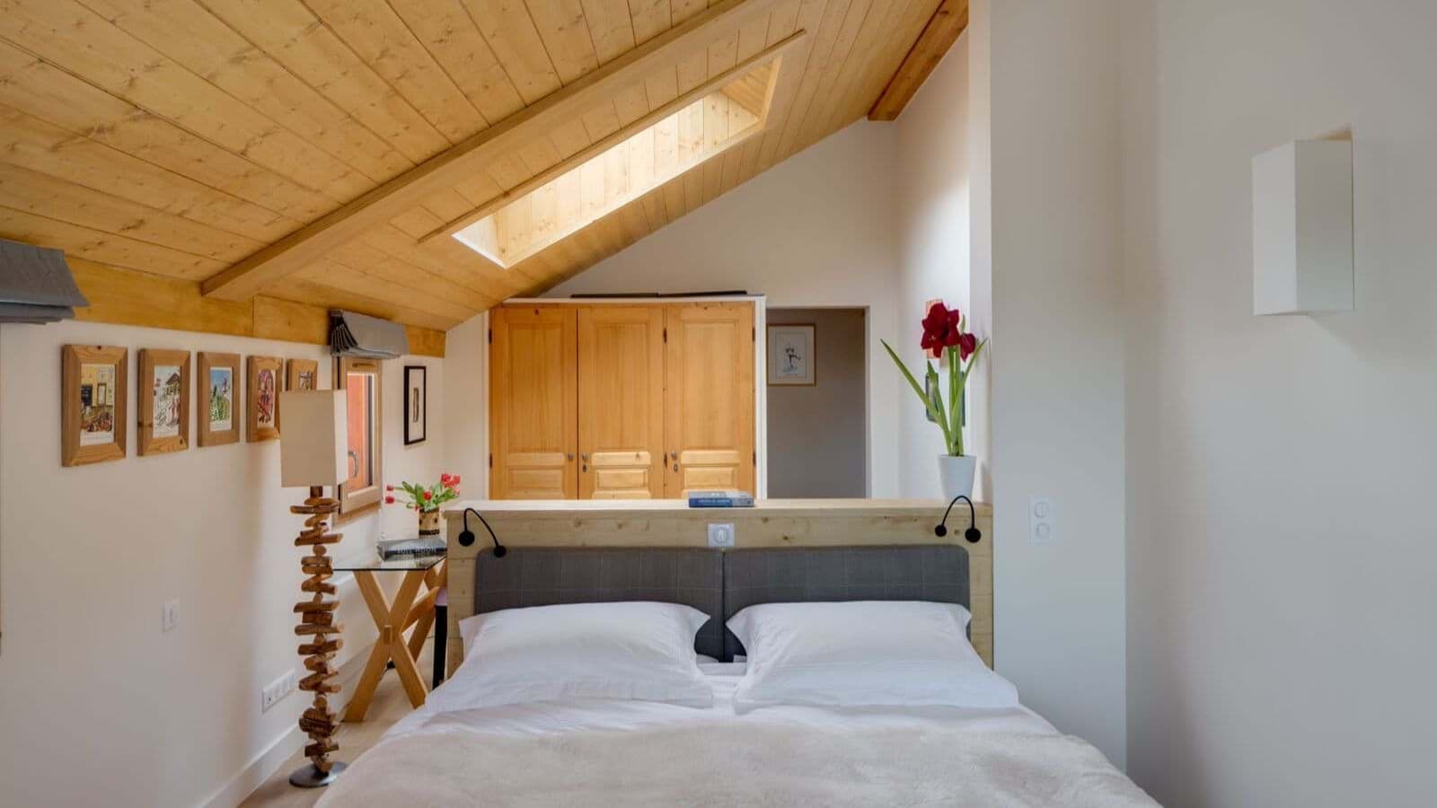 Loft bedroom with queen bed, skylight, and built-in wooden wardrobes