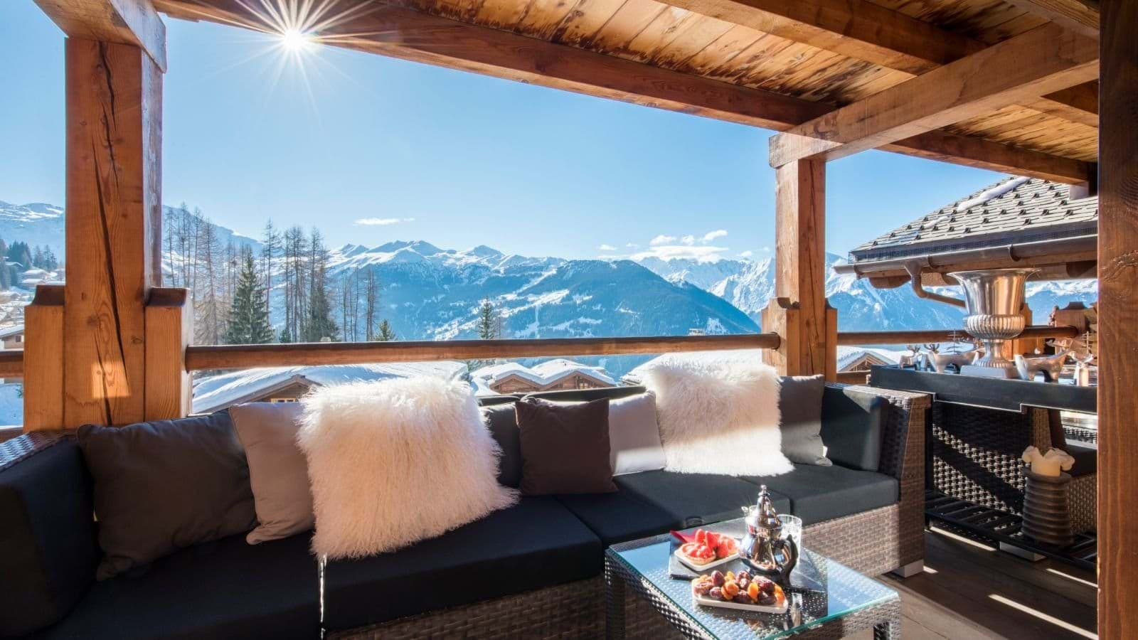 Covered terrace with wicker sectional and panoramic mountain views