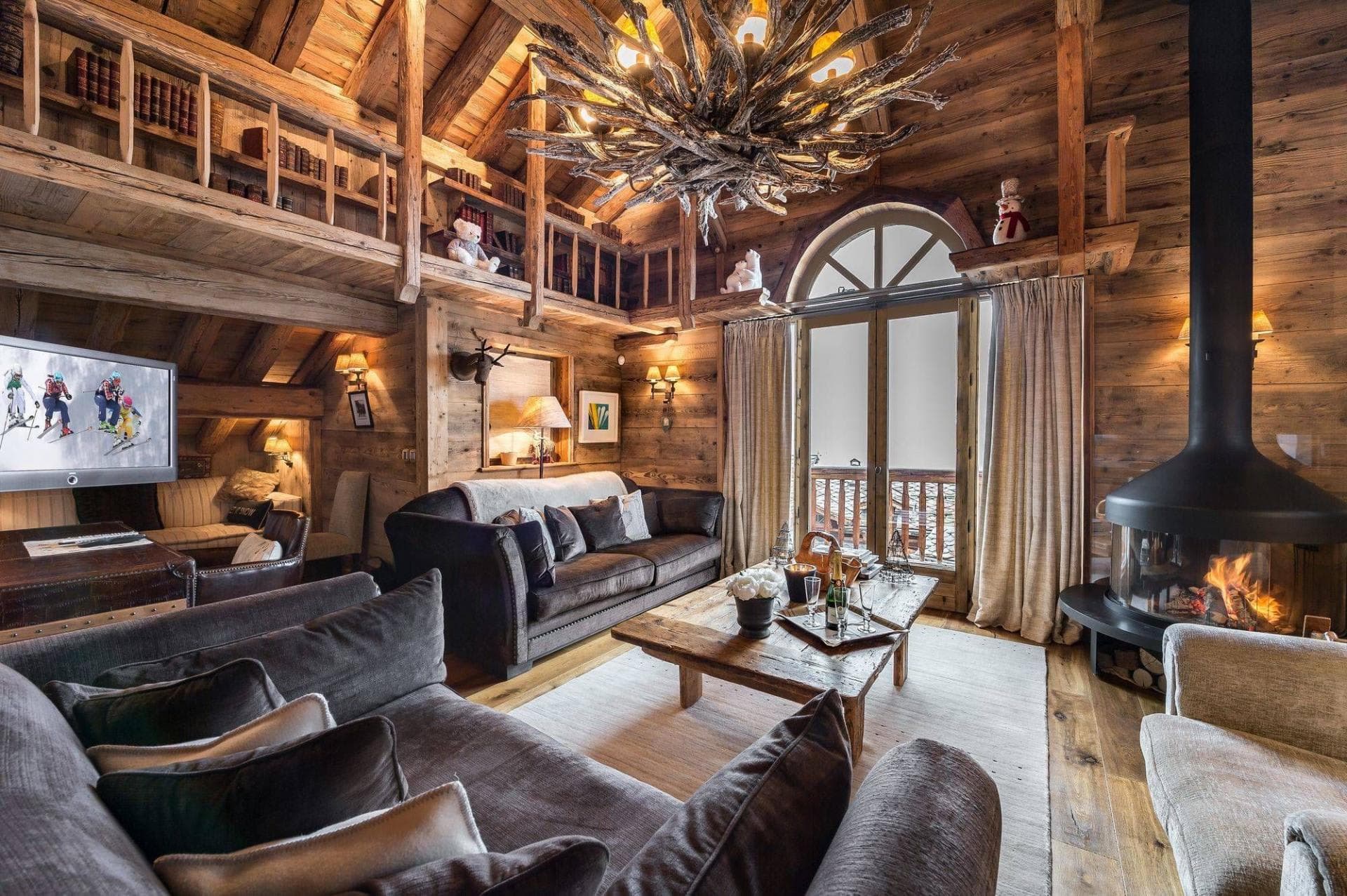 Living area with circular wood fireplace and library loft