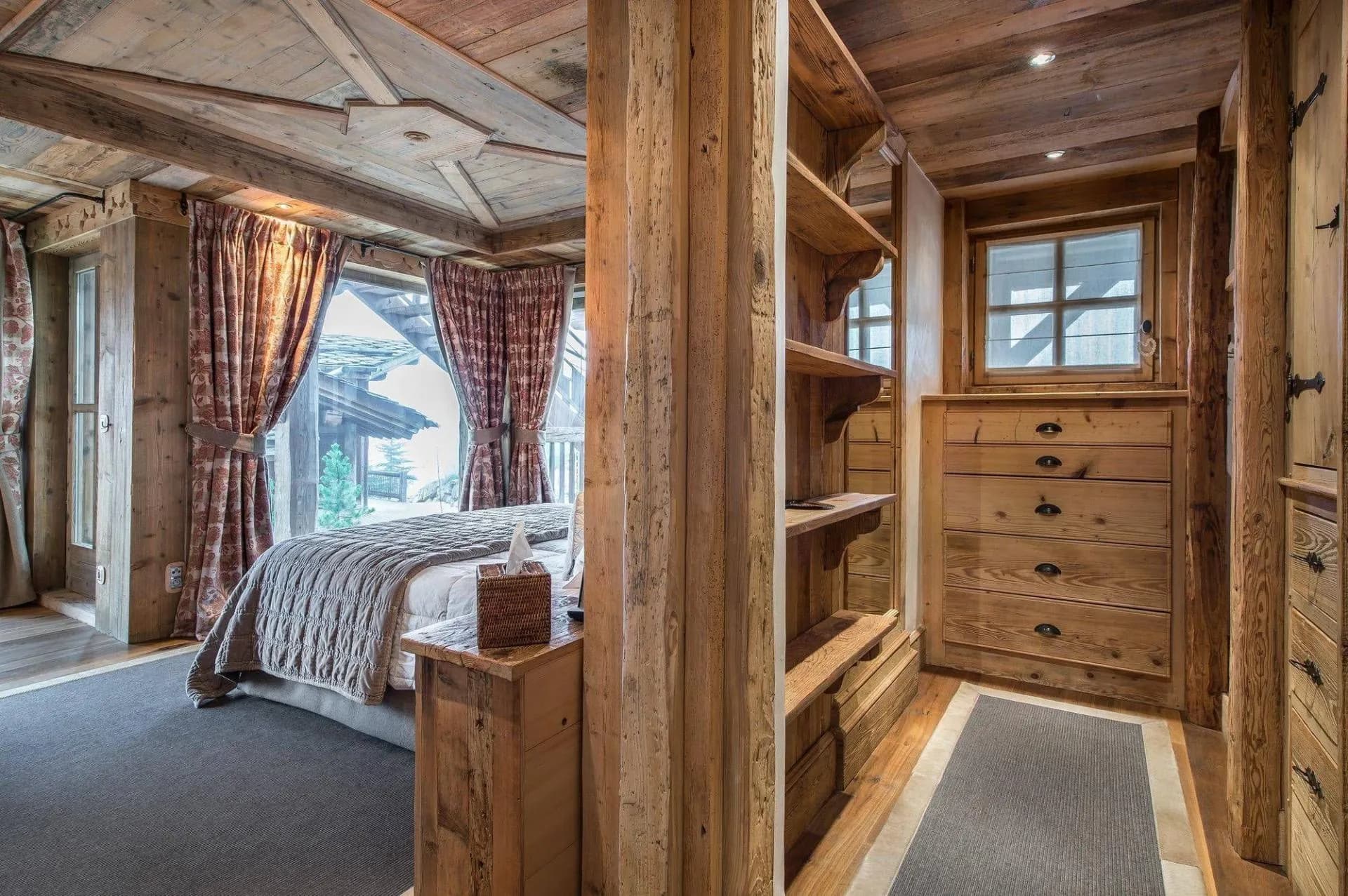 Double bedroom viewed past timber wardrobe and shelving