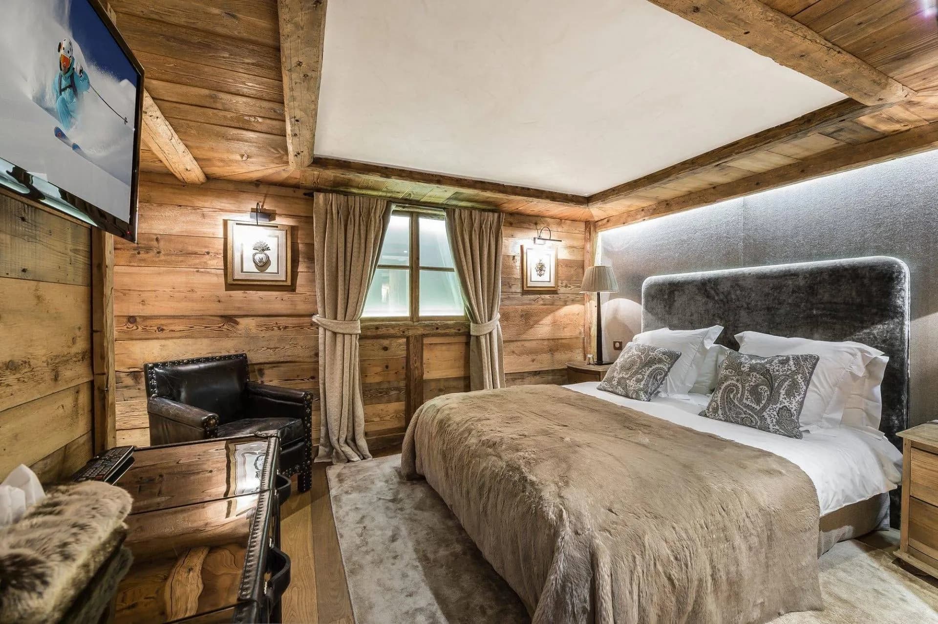 Double bedroom with upholstered headboard, television and window