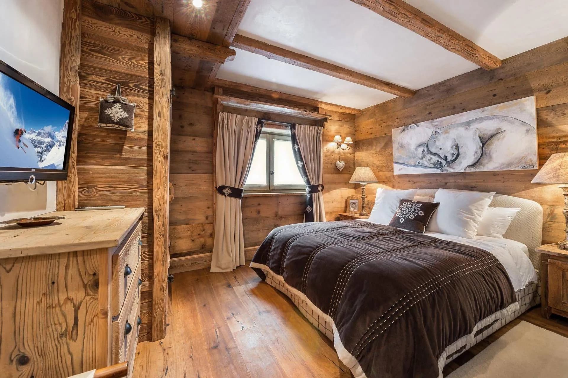 Double bedroom with timber walls and television