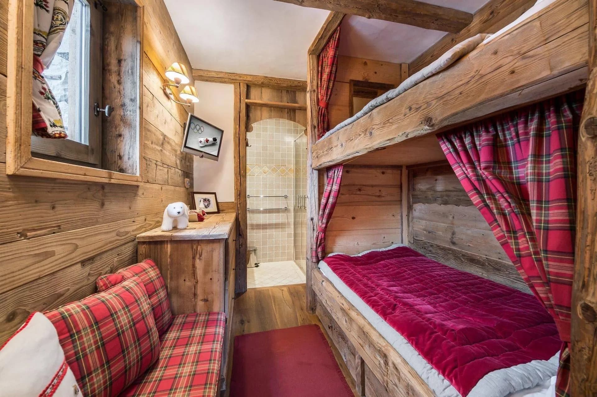 Children’s bunk bedroom with timber beds and red curtains