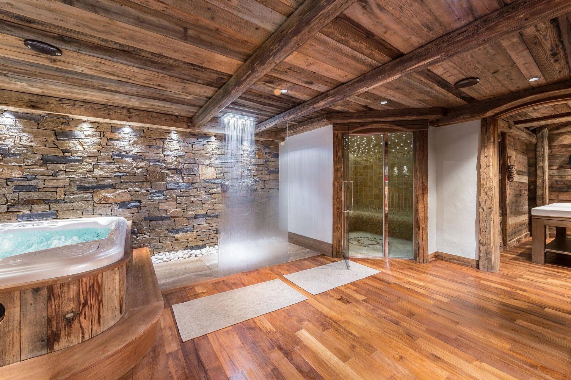 Private wellness suite with hot tub, rainfall shower, and glass-enclosed steam room