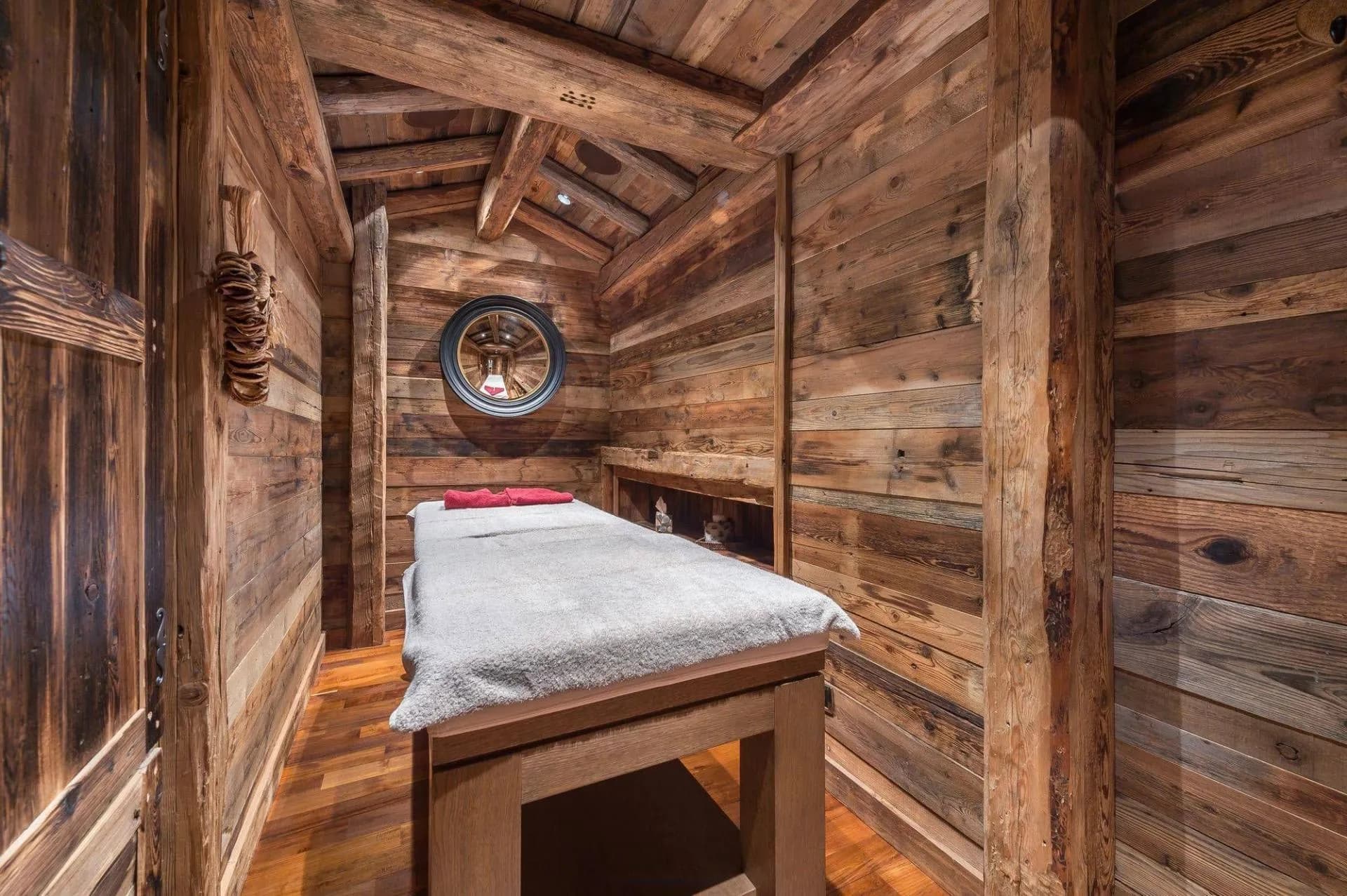Massage room with treatment table and timber walls