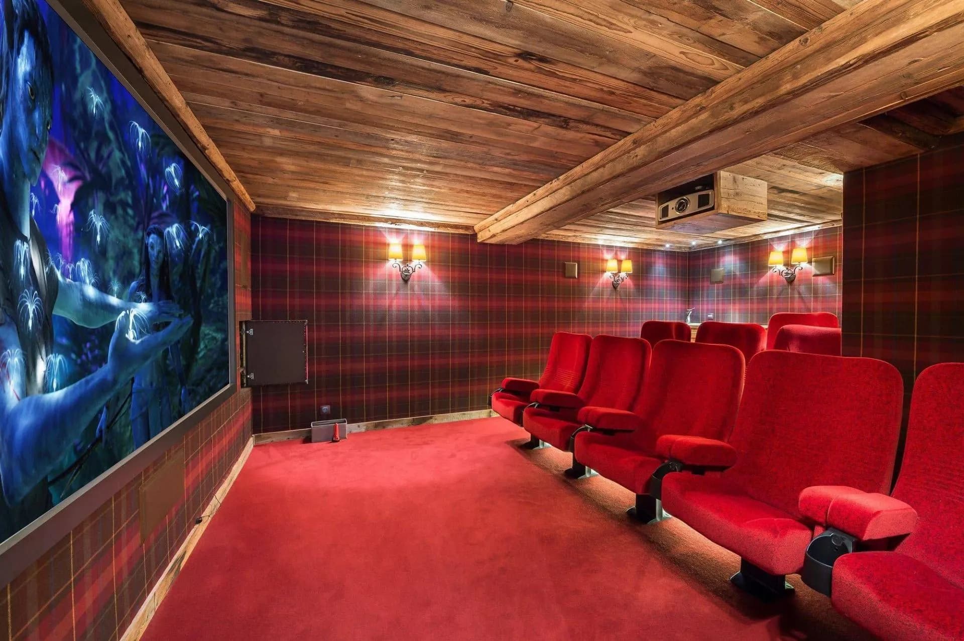 Cinema room with red armchairs and large screen