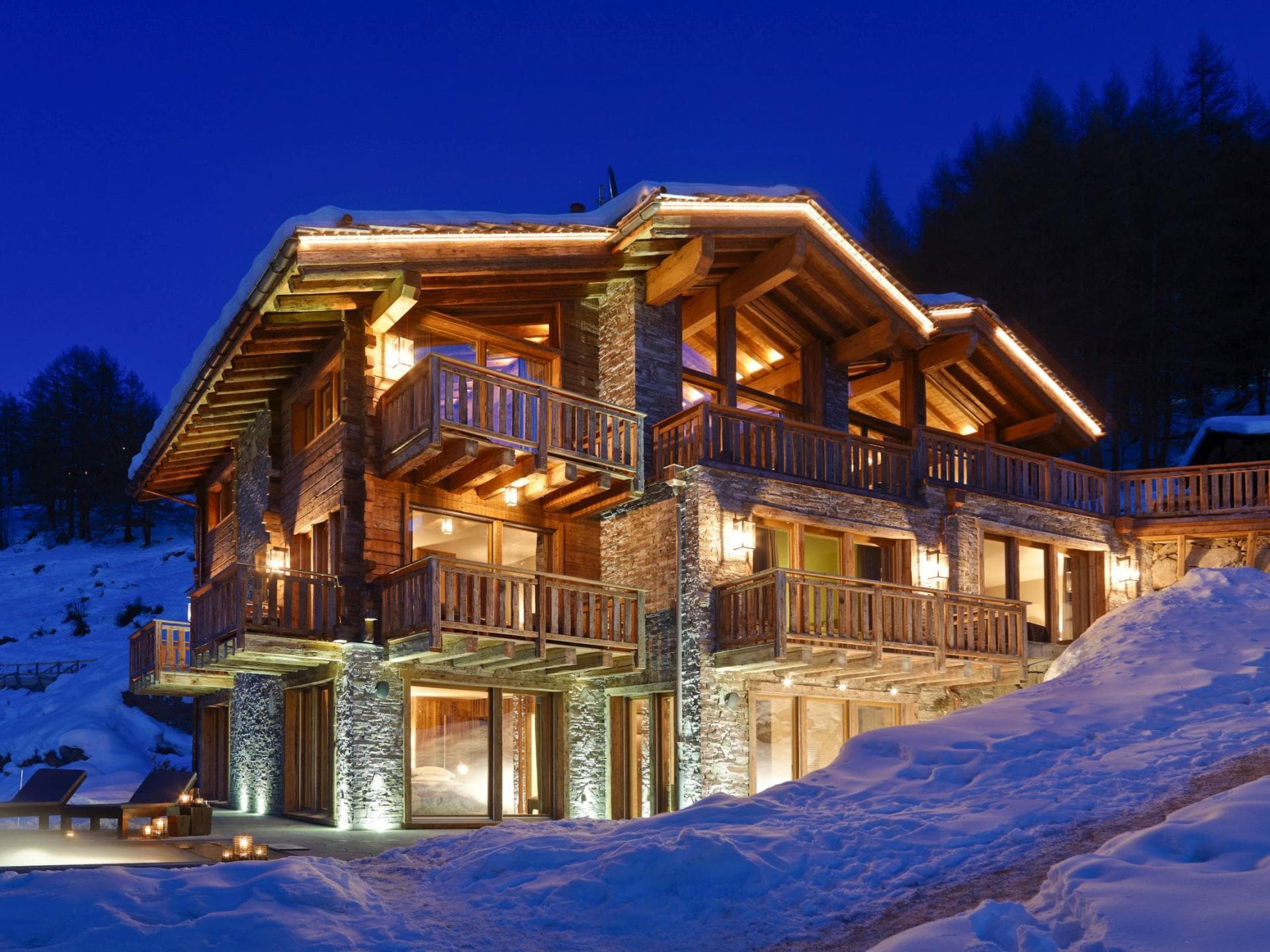 Ski-in/ski-out chalet with private balconies and stone exterior at night