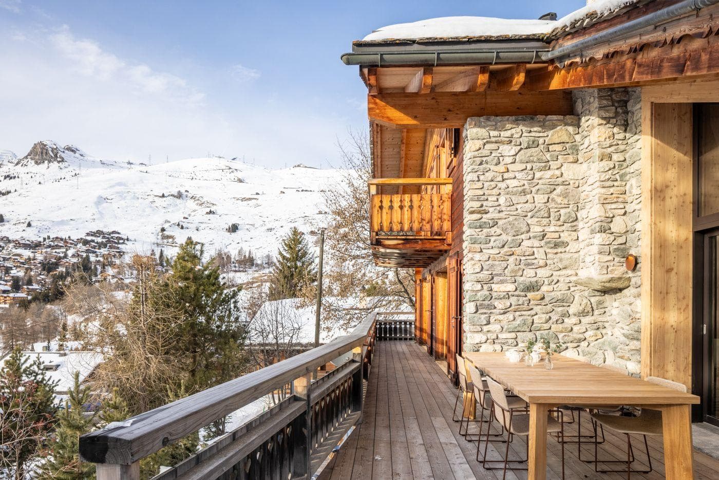 Wraparound deck with alpine valley views; stone and wood construction