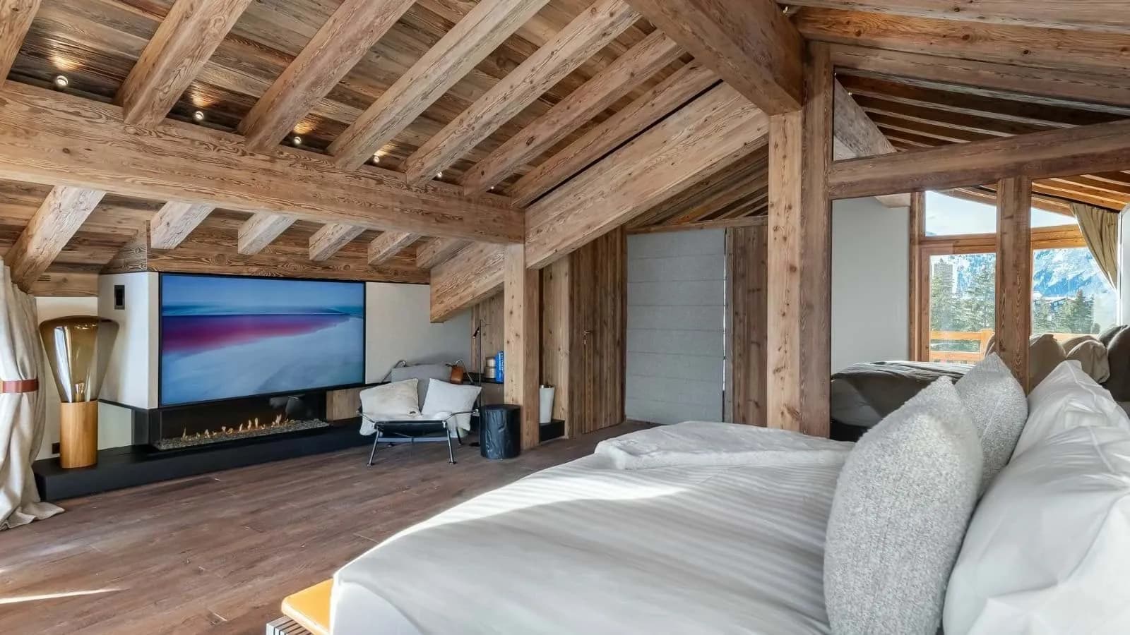 Double bedroom with a linear fireplace and mountain views