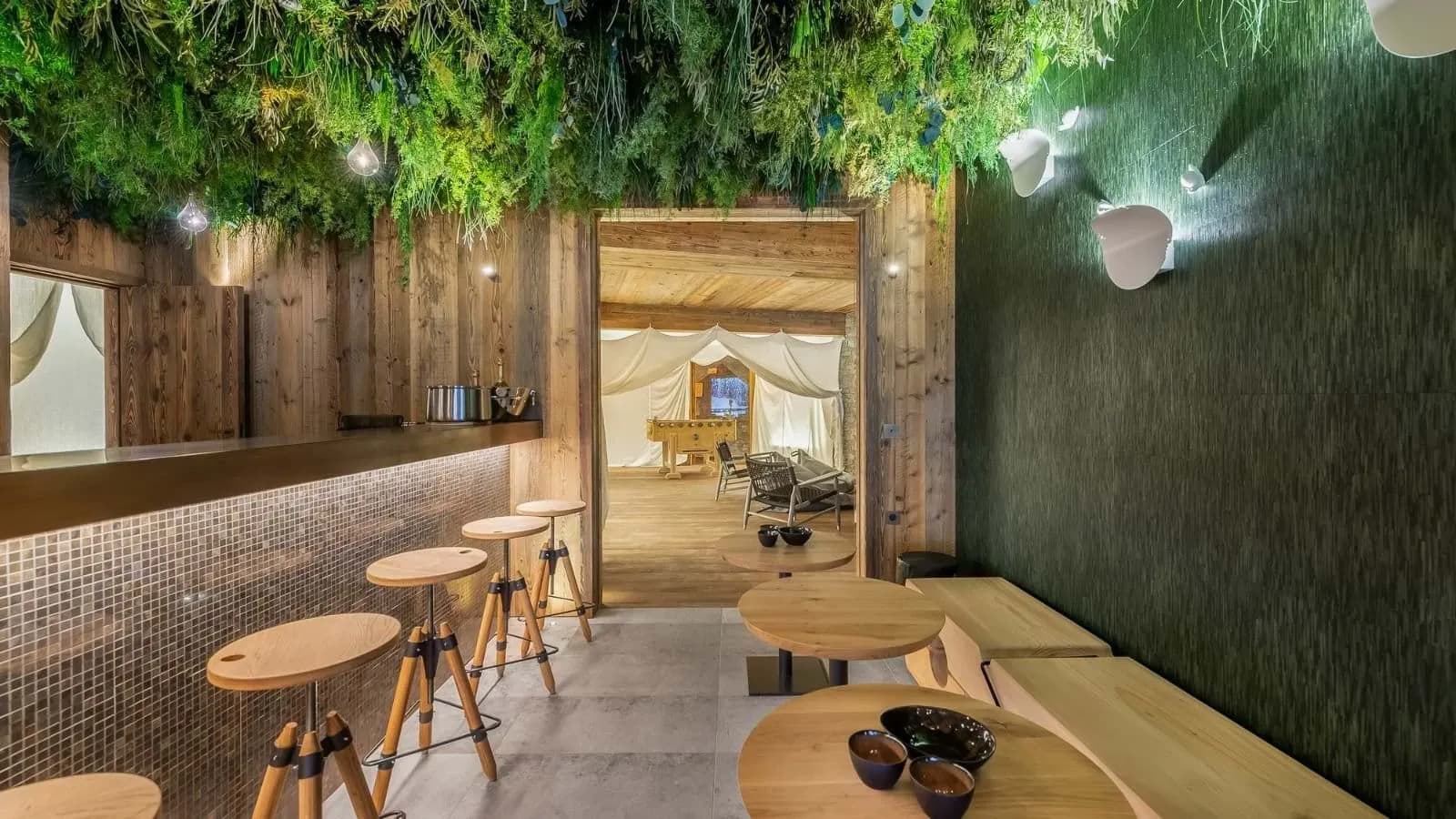 Lower-level bar with a planted ceiling beside the games room