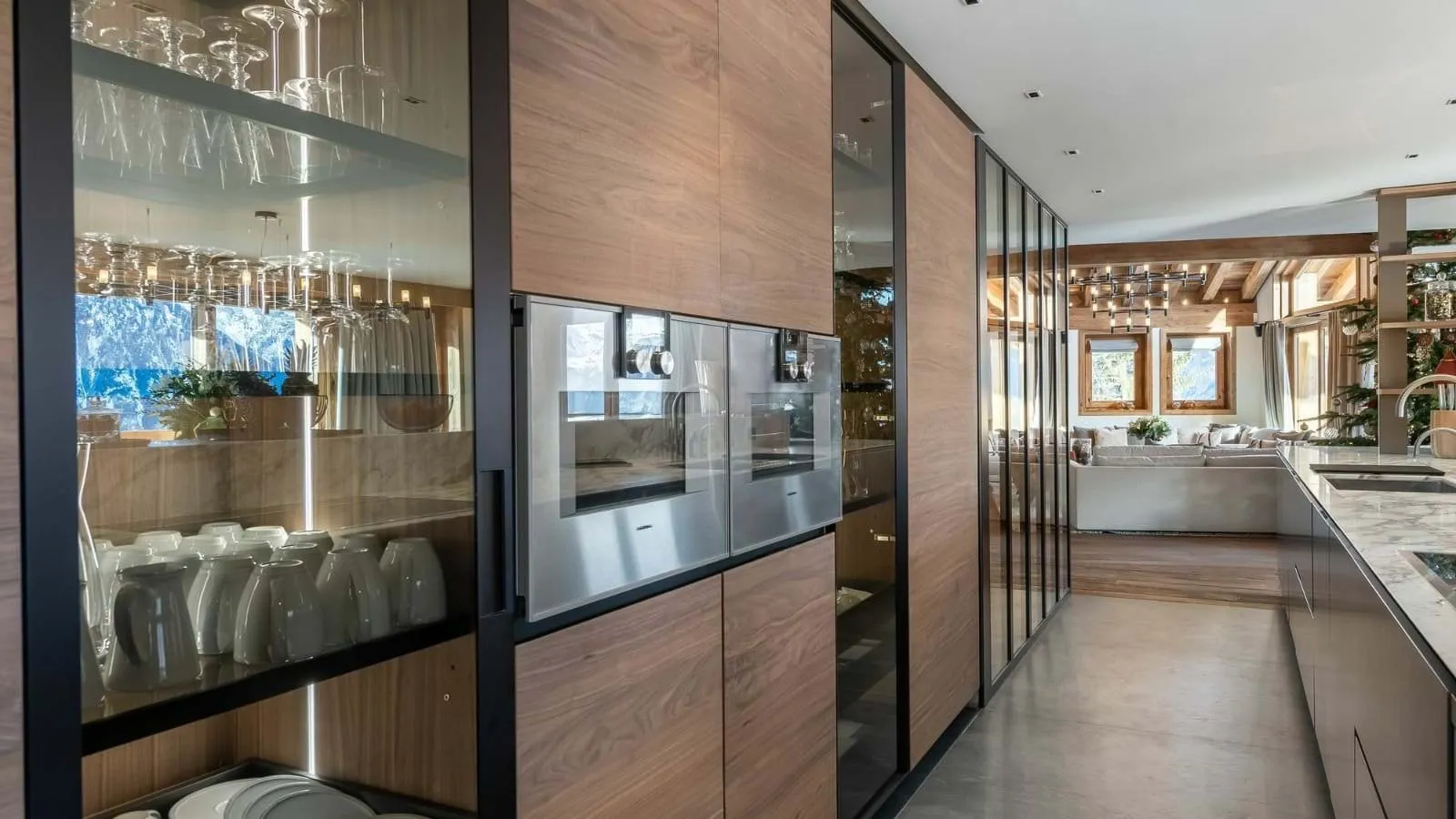 Kitchen with integrated ovens and glass-front cabinetry