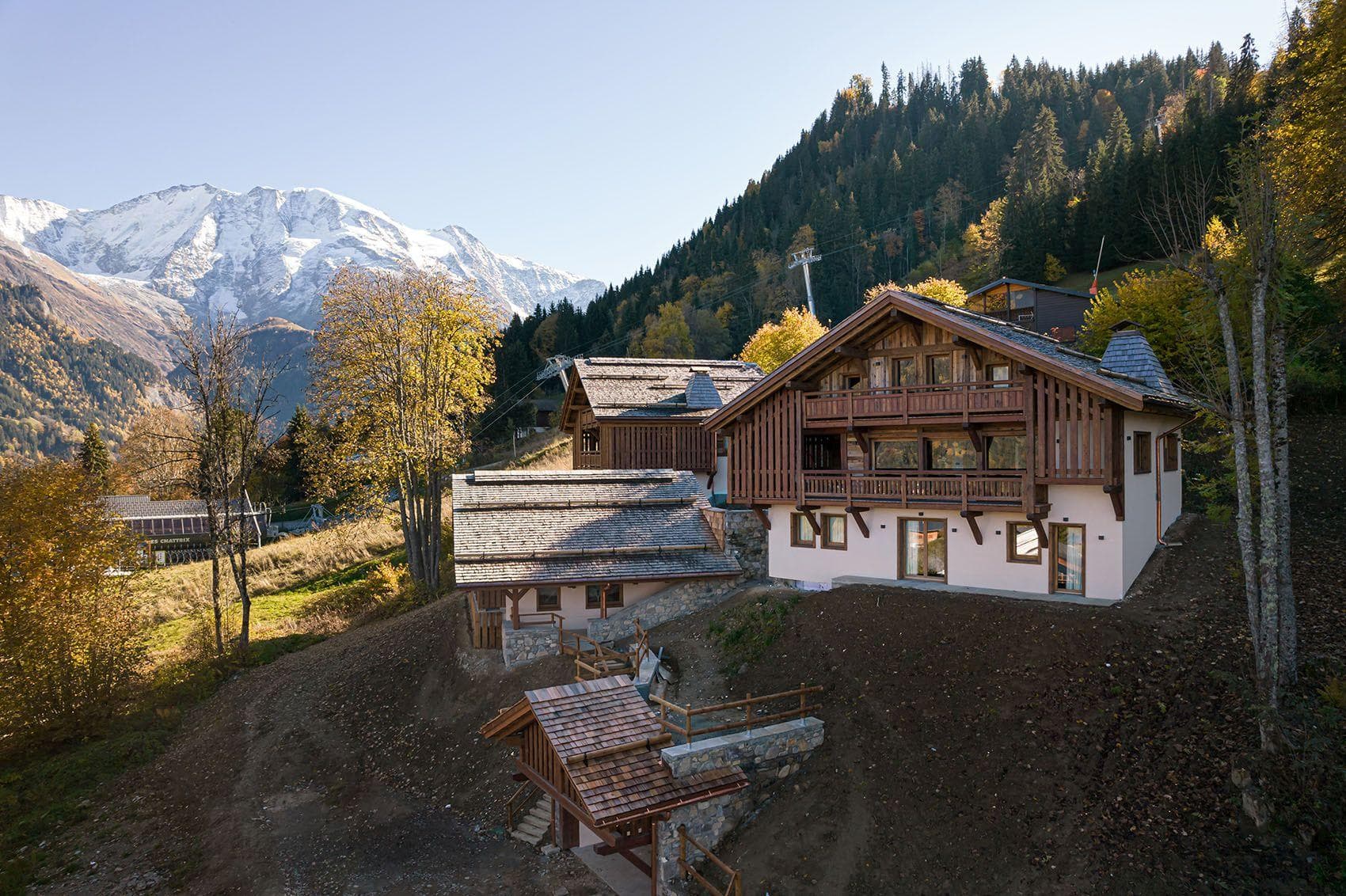 Chalet exterior with wooden balconies and views of snow-capped peaks