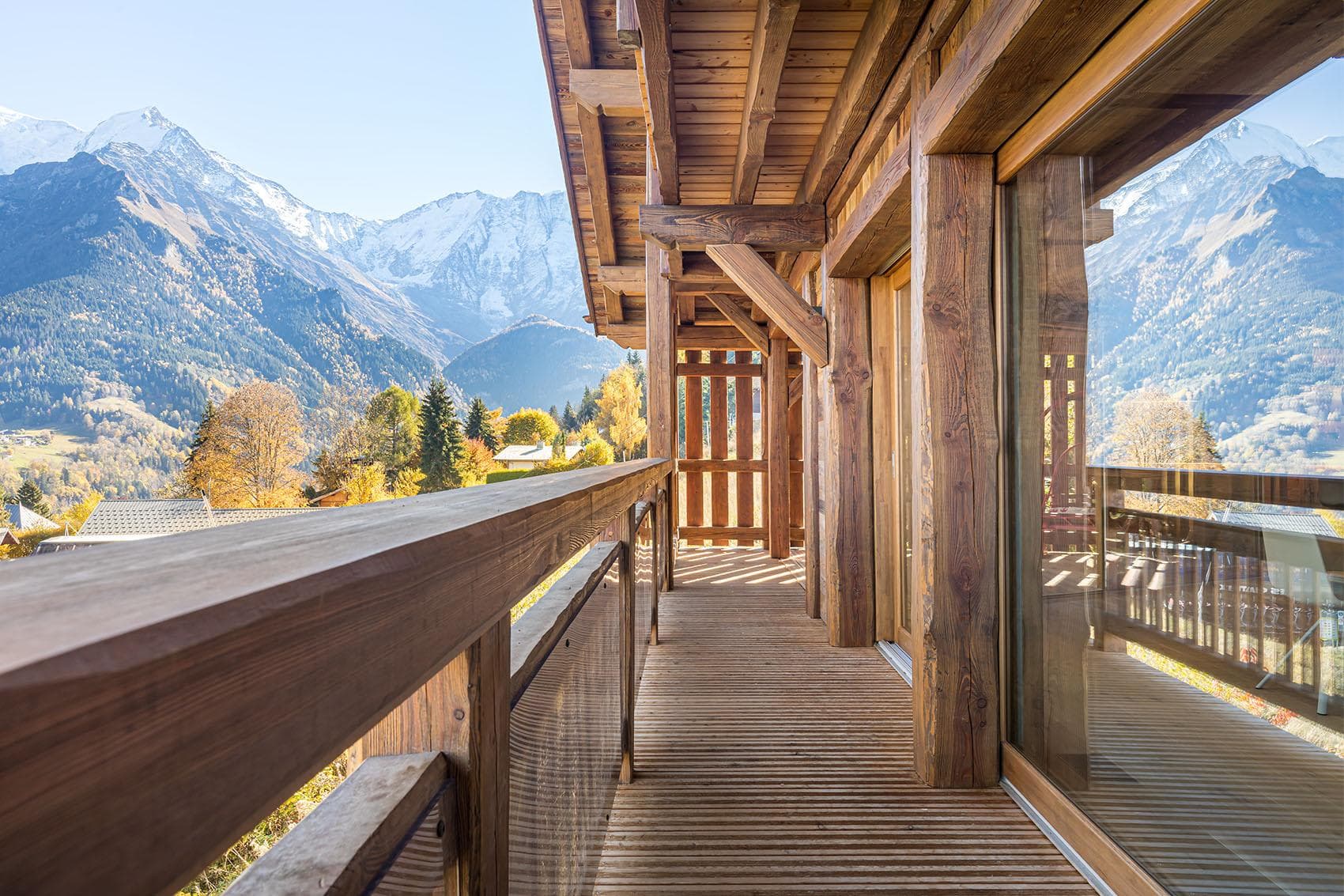 Timber balcony with glass railing and mountain views