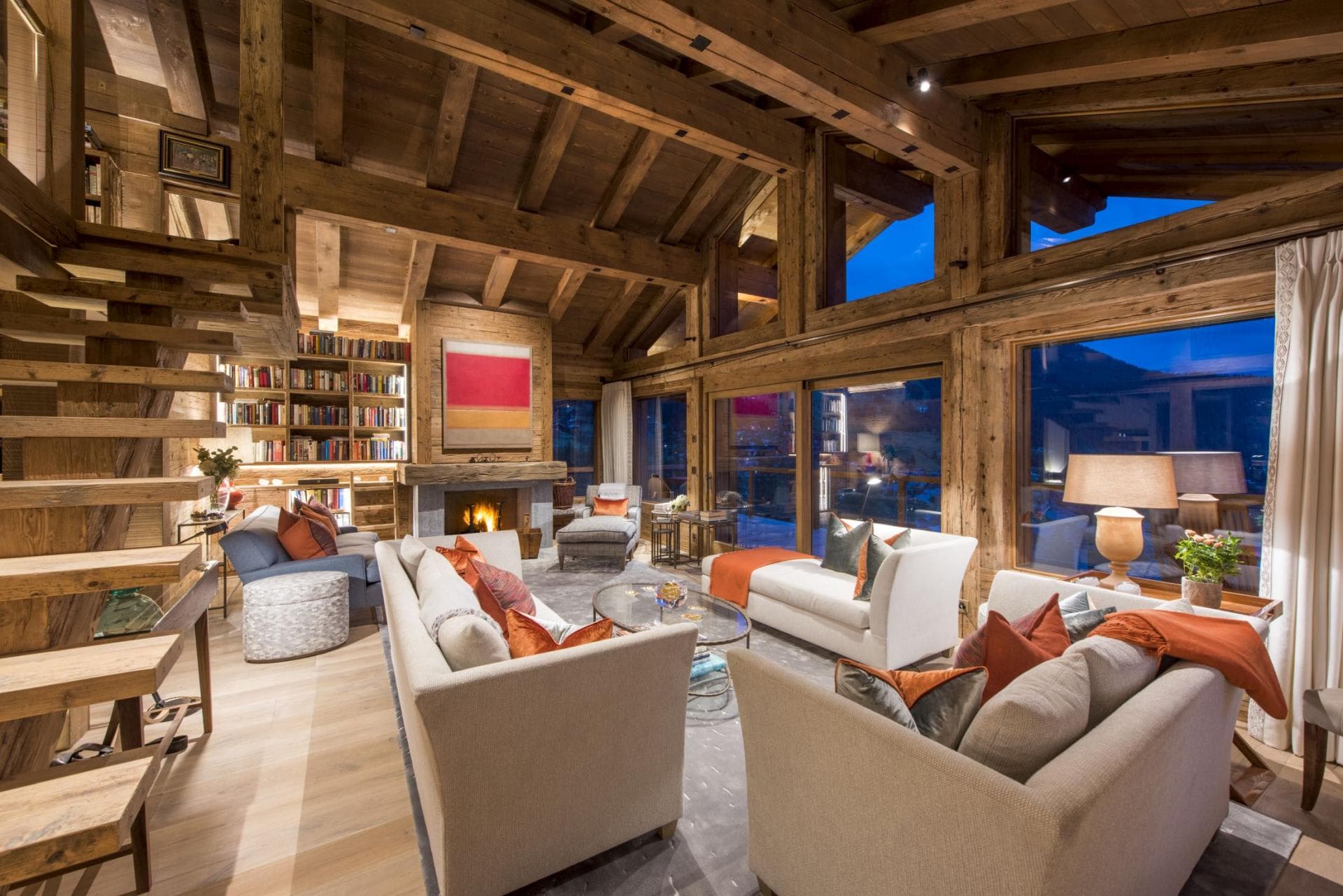 Living area with wood-burning fireplace and floor-to-ceiling windows; seating for 8