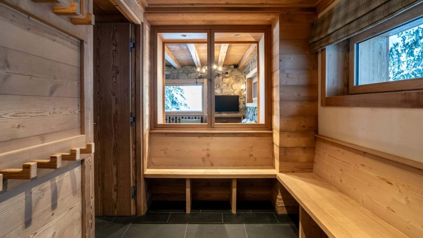 Mudroom with built-in wooden benches and gear storage hooks