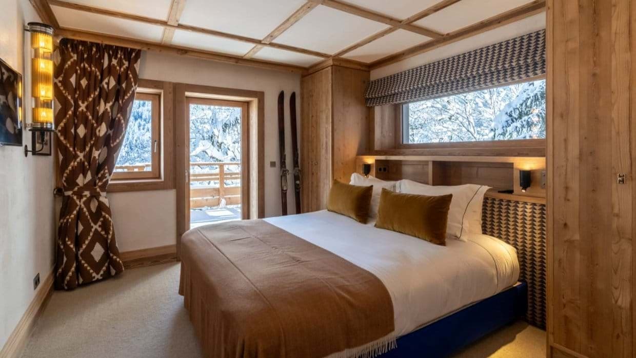 King bedroom with balcony access and snowy mountain views