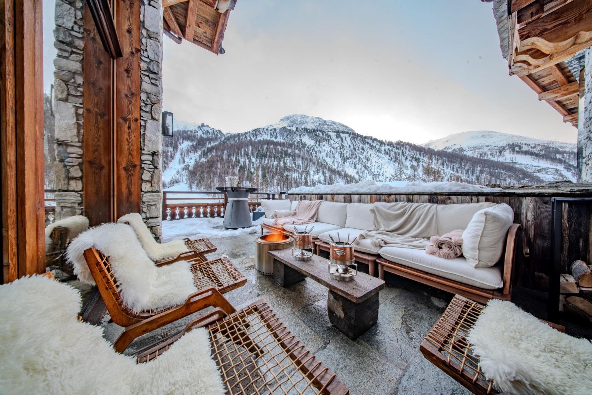 Outdoor terrace with fire pit and ski slope views