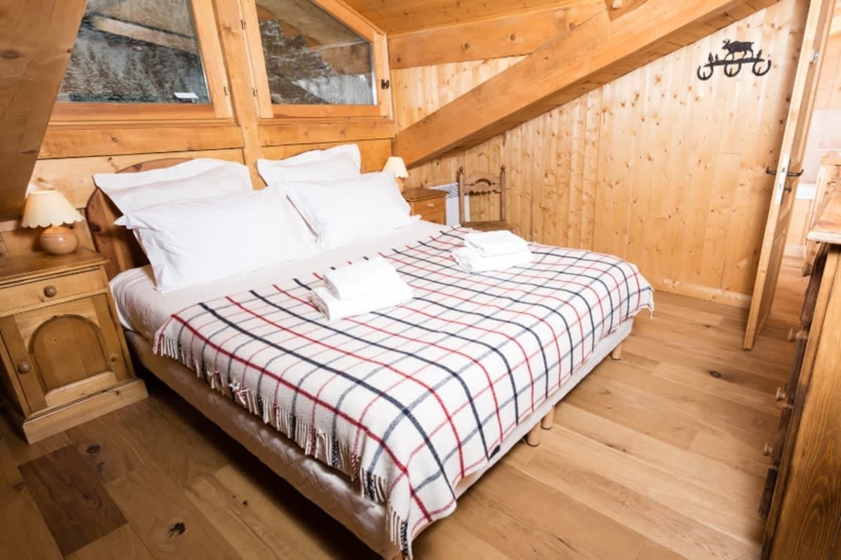 Attic bedroom with queen bed and wood-paneled walls