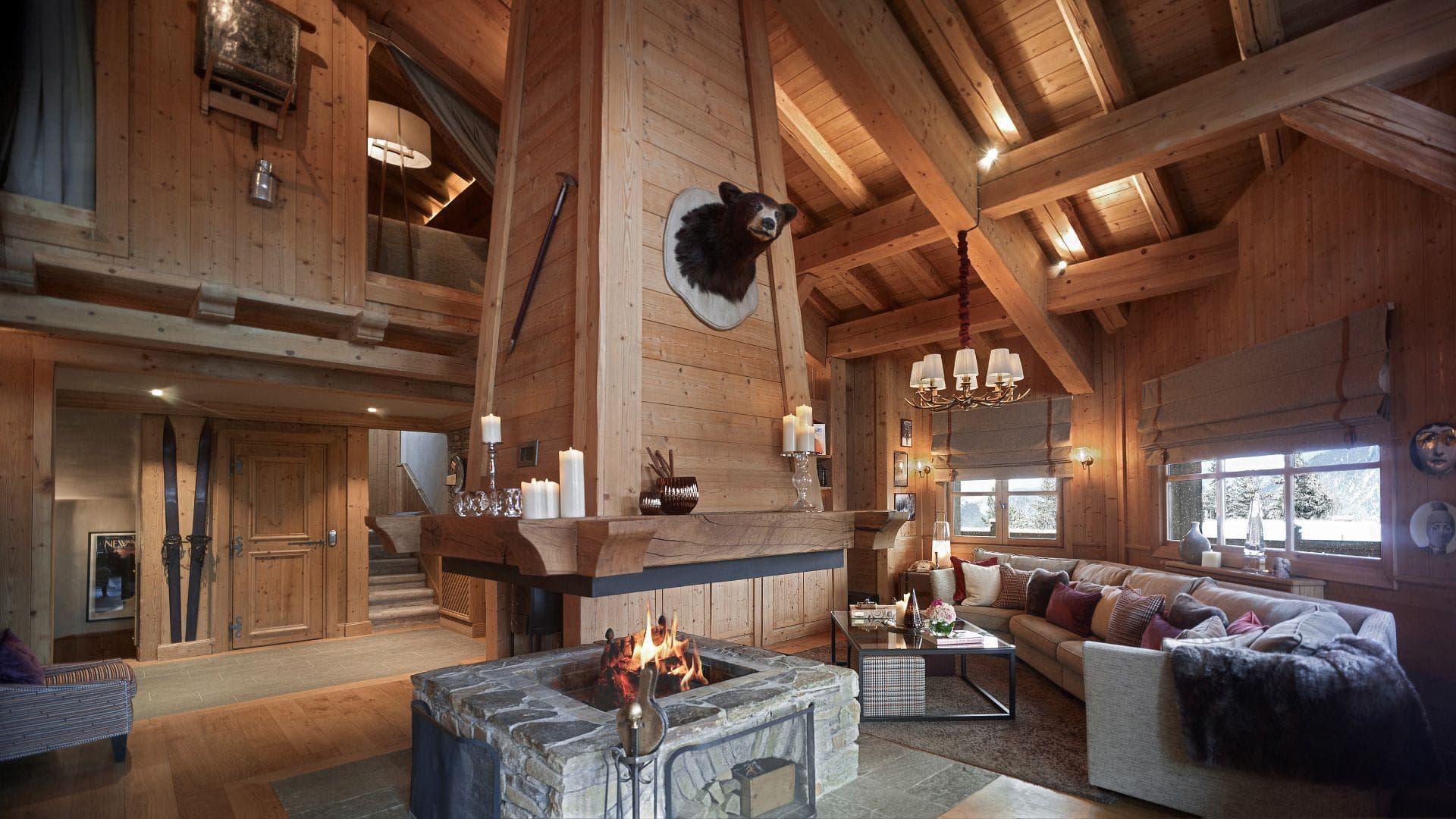 Living area with open stone fireplace and mezzanine loft access