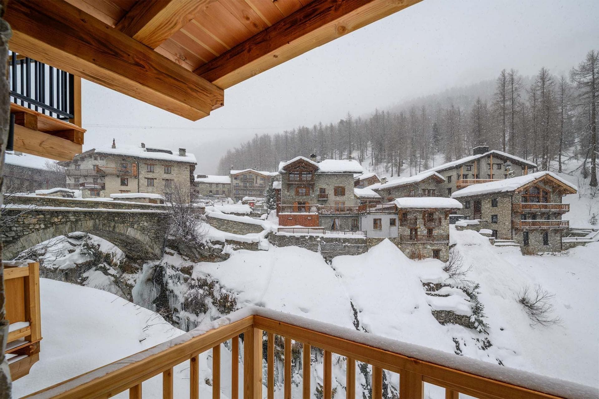 Private balcony with views of stone bridge and snow-covered village