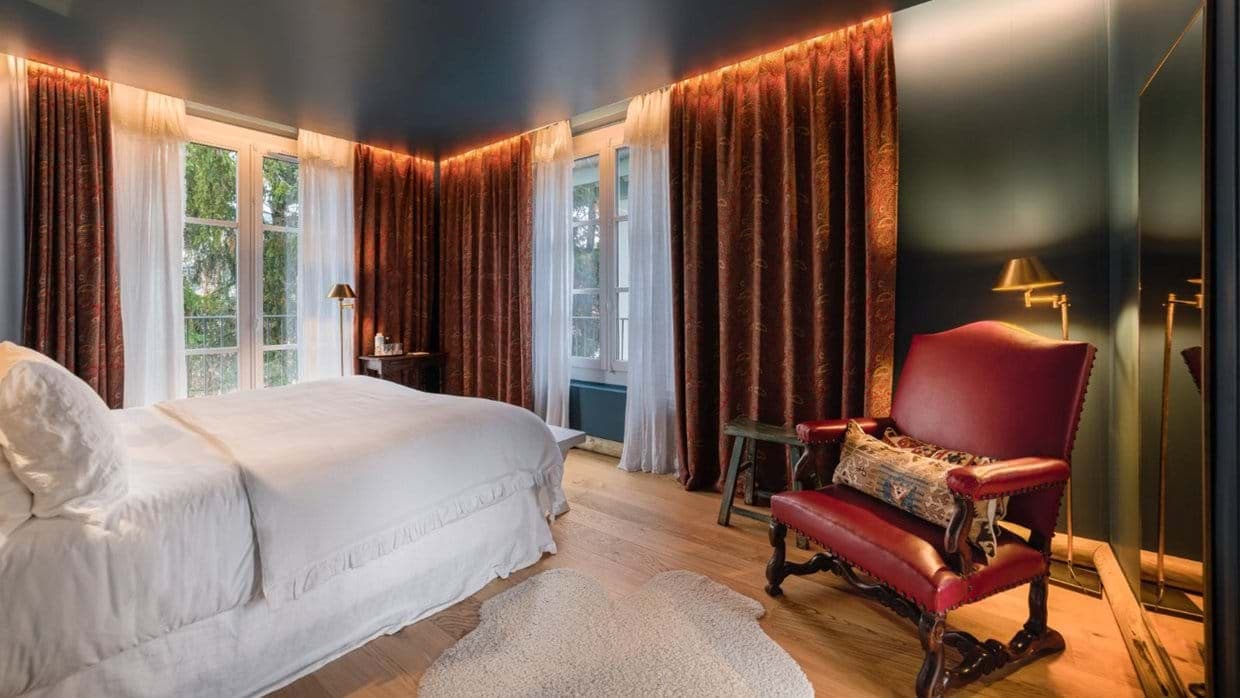 Bedroom with floor-to-ceiling windows and leather reading chair