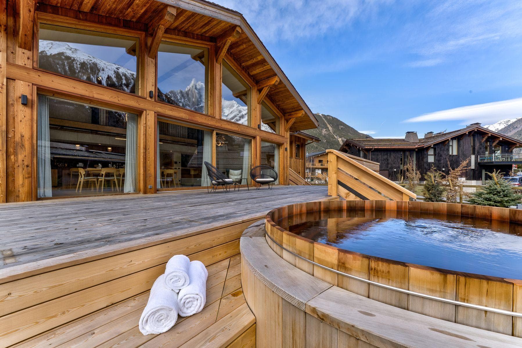 Cedar hot tub on wooden deck with snow-capped mountain views