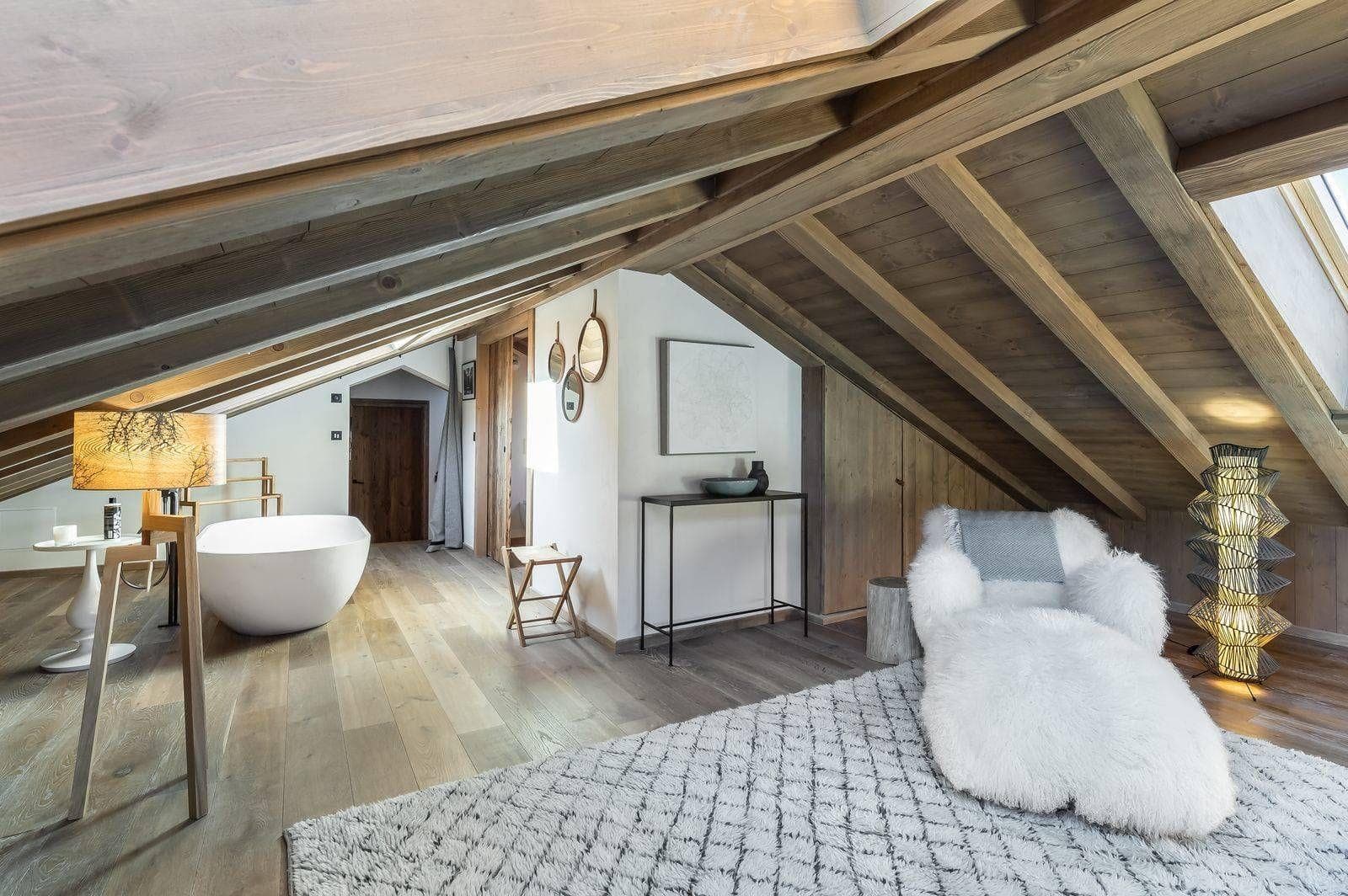 Top-floor lounge and freestanding bathtub beneath timber beams