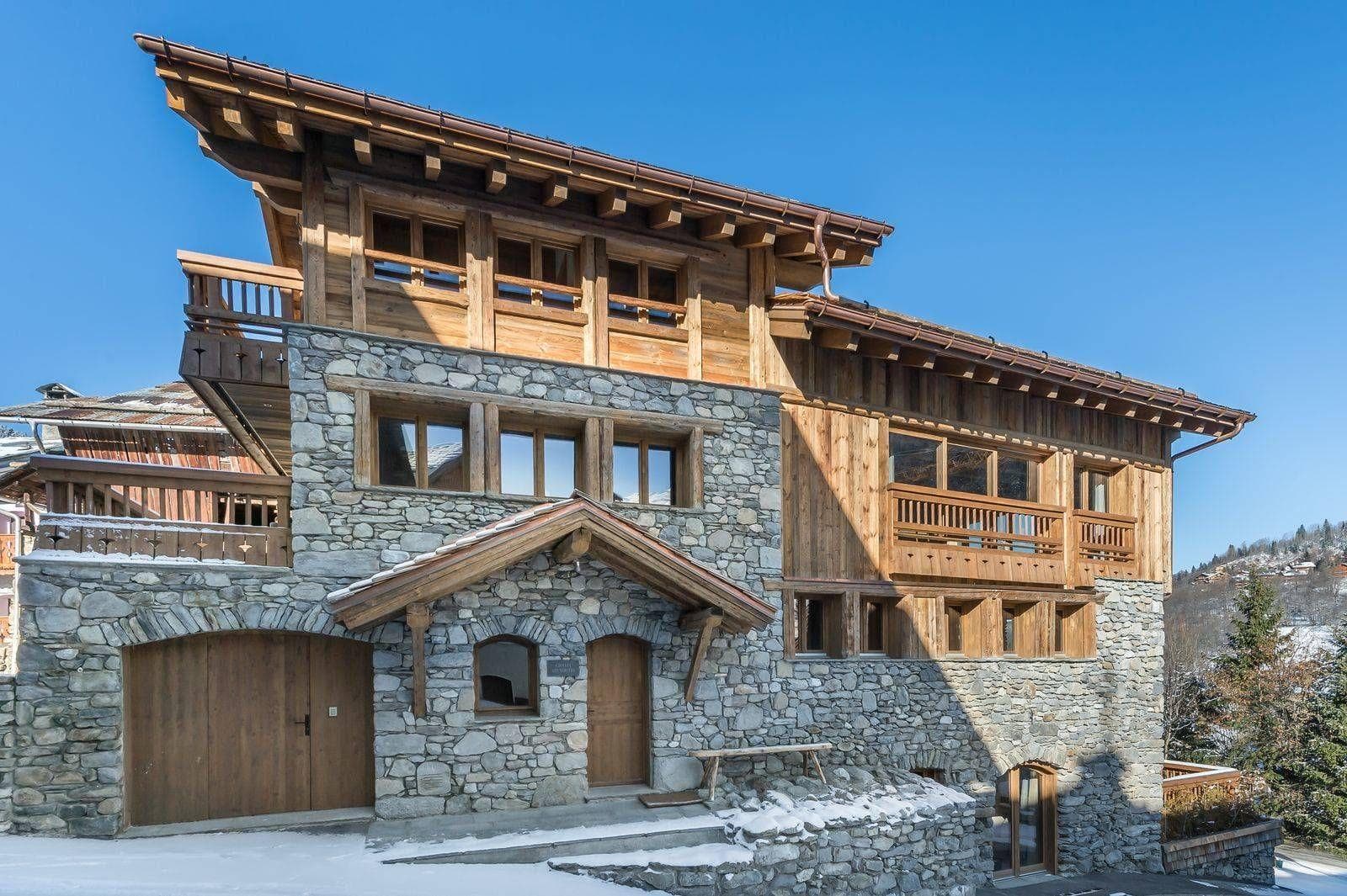 Chalet exterior with stone facade, heated driveway, and attached single-car garage