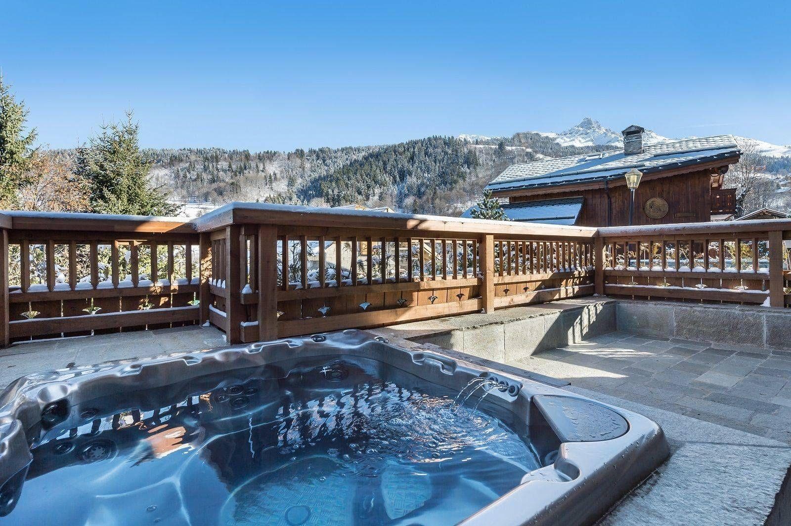 Private outdoor hot tub with mountain views and stone terrace