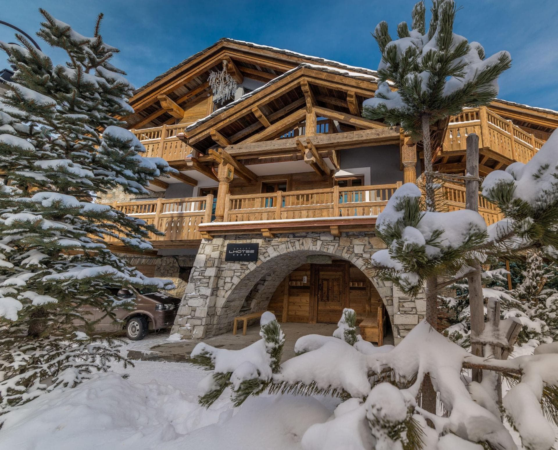 Chalet exterior with stone archway entrance and private driveway parking