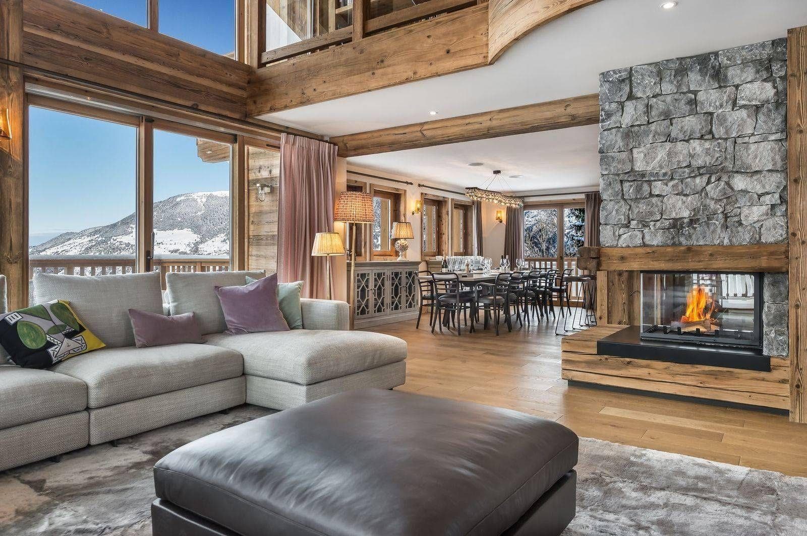 Open-plan living and dining area arranged around a stone fireplace